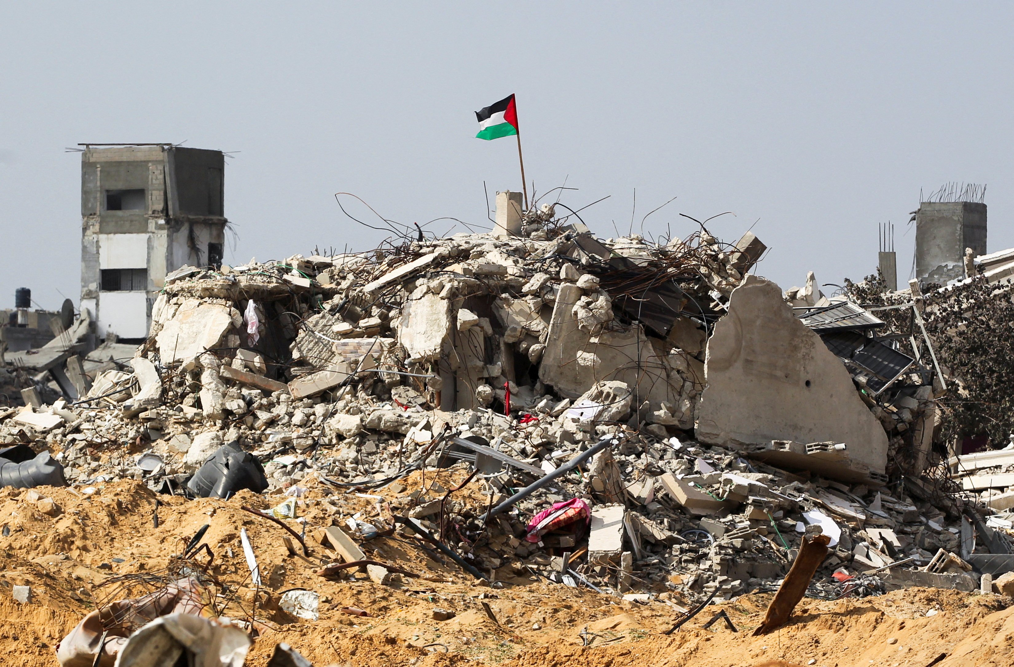 A Palestinian flag flutters among the rubble of buildings in Rafah, the southern Gaza Strip, on Tuesday. Photo: Reuters