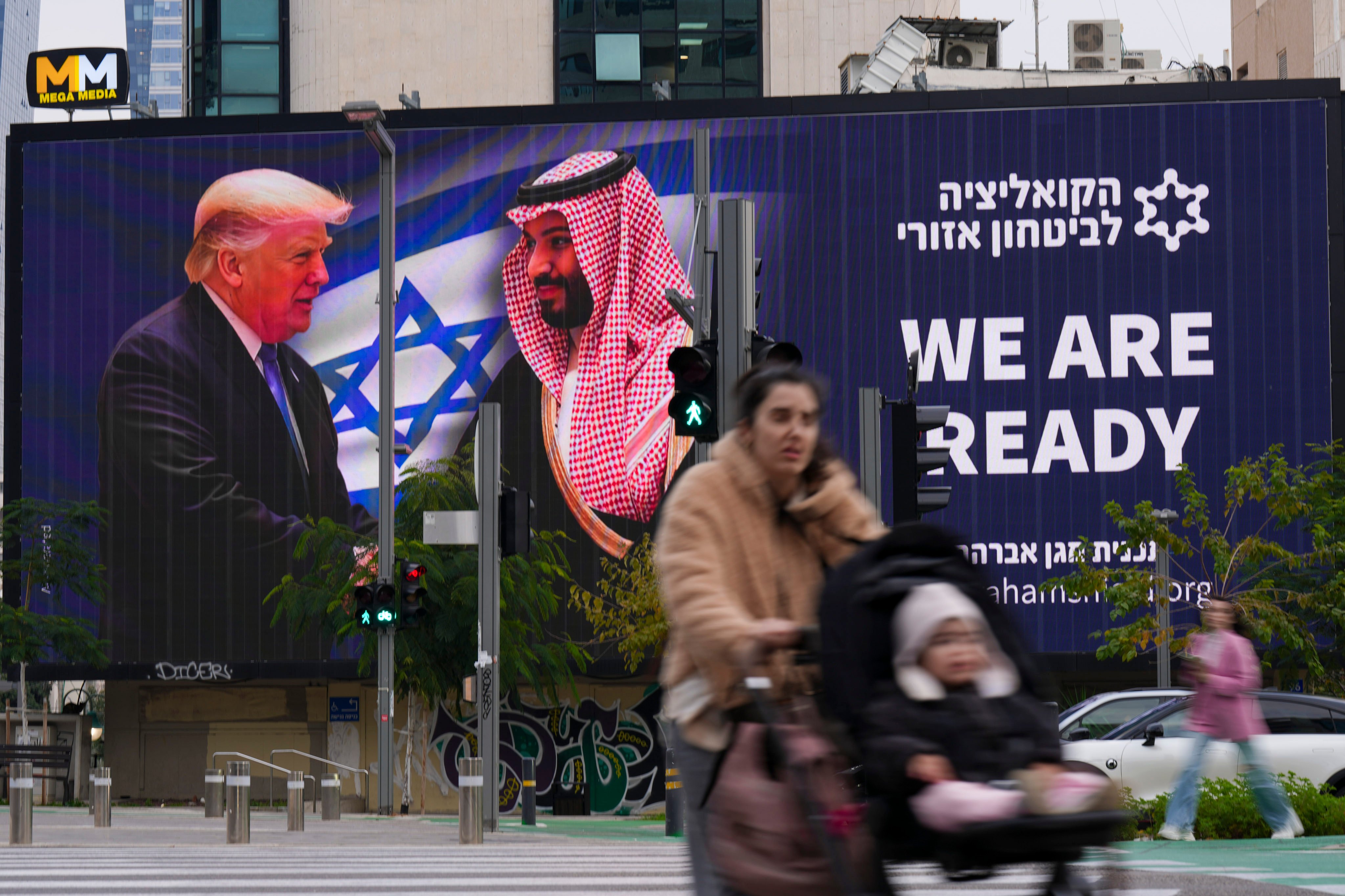 People walk past an electronic billboard that shows US President Donald Trump shaking hands with Saudi Crown Prince Mohammed bin Salman in Tel Aviv on February 3. The era of oil’s waning supremacy may best be seen in Saudi Crown Prince Mohammed bin Salman’s plan to broaden investment and trade with the US. Photo: AP