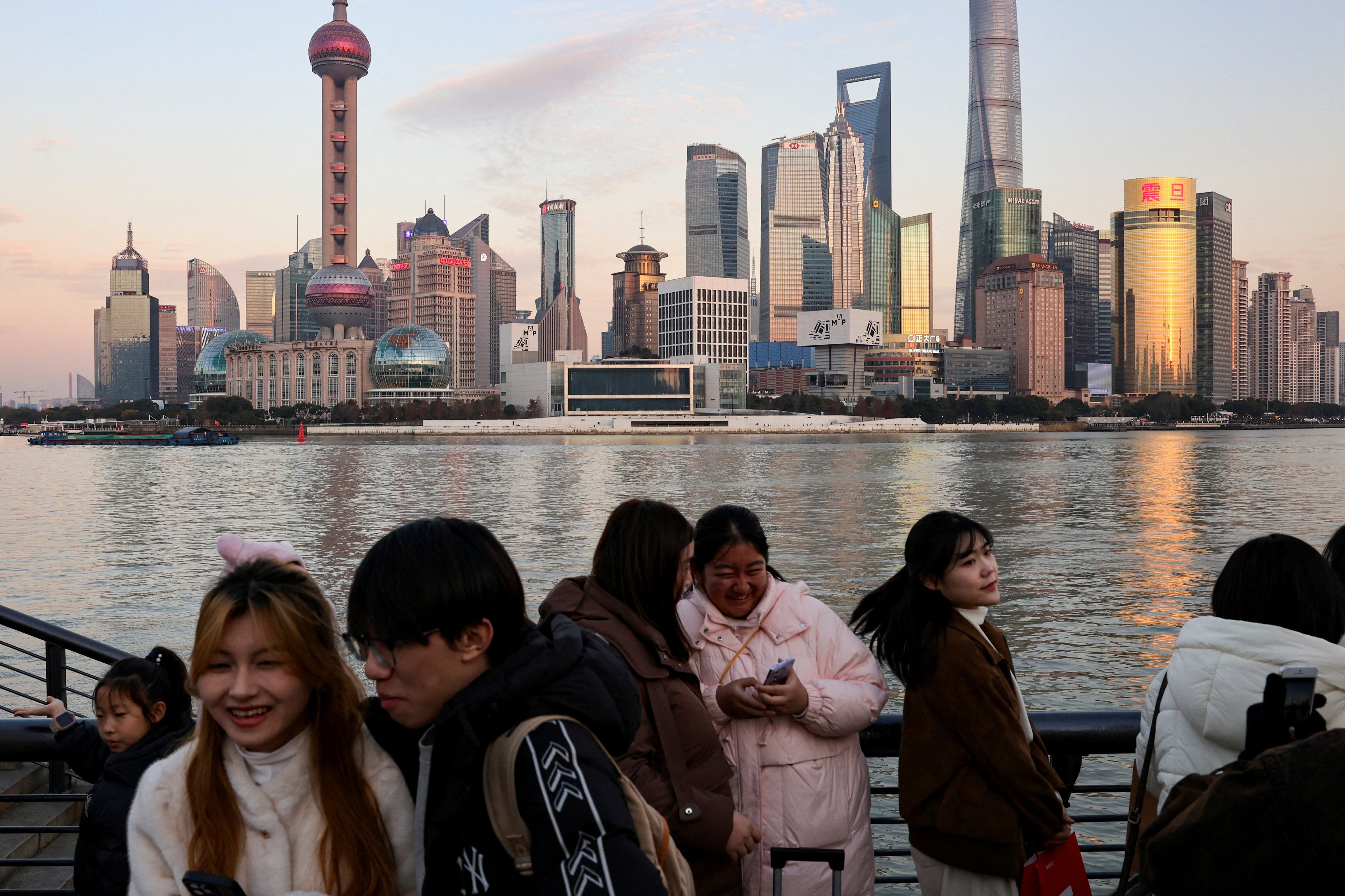 People gathered on The Bund in Shanghai with the city’s financial district in the background. Photo: Reuters 