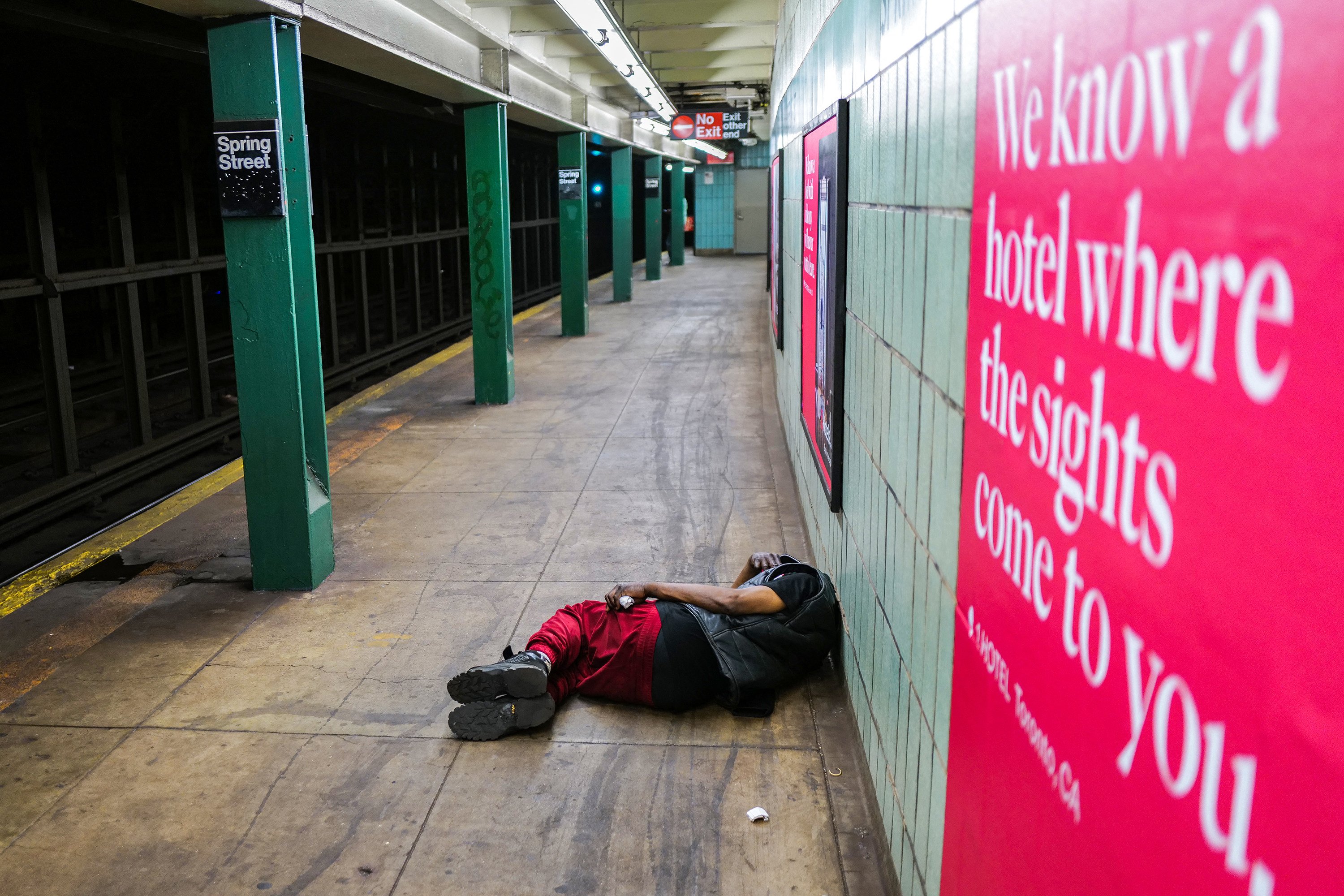 A homeless man smokes a cigarette while lying on the ground in a subway station of the Manhattan borough of New York on May 7, 2024. Photo: AFP / Getty Images / TNS