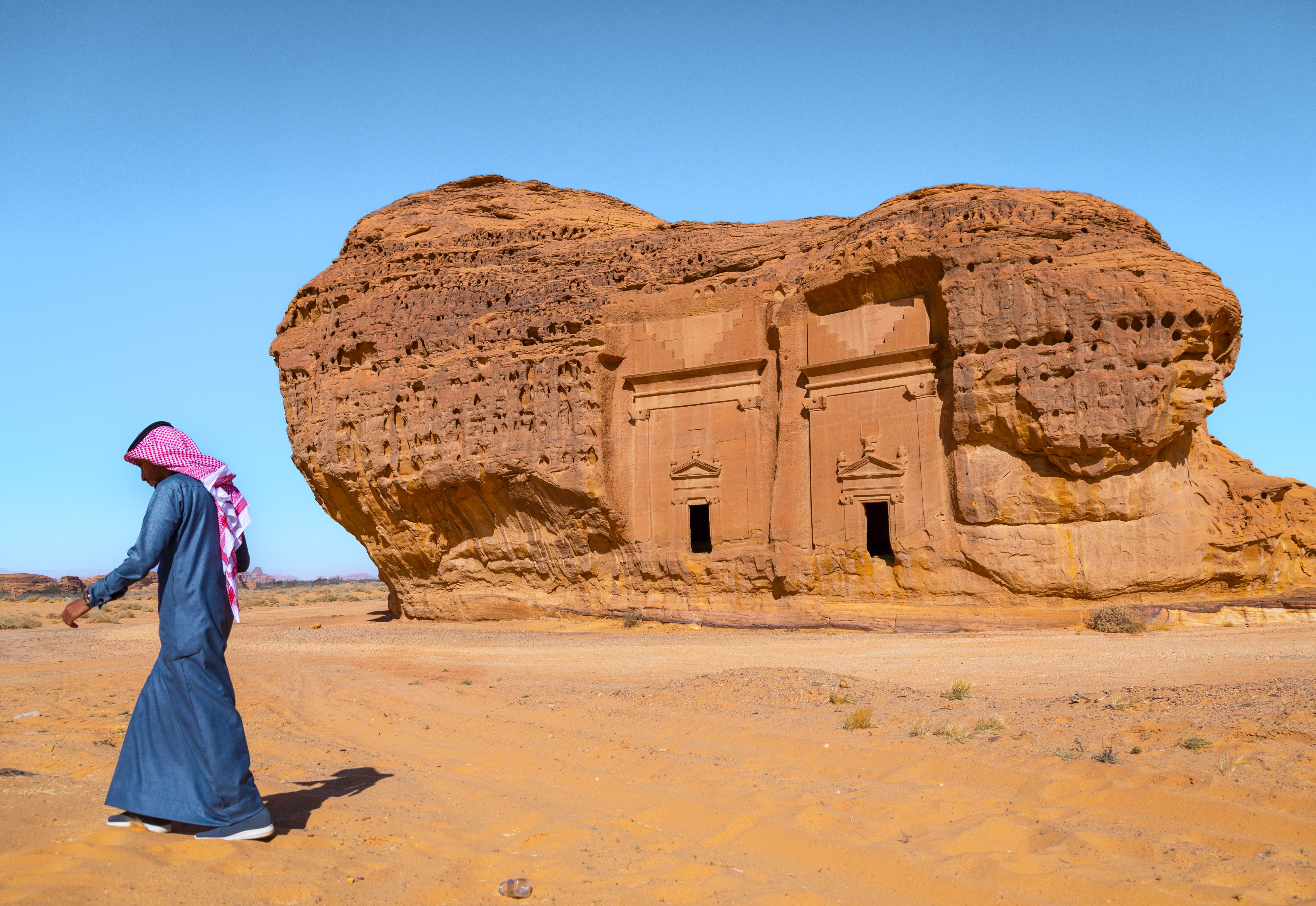 A Saudi man walks in front of tombs in the al-Hijr archaeological site at Hegra, also known as Mada’in Saleh. Photo: Getty Images