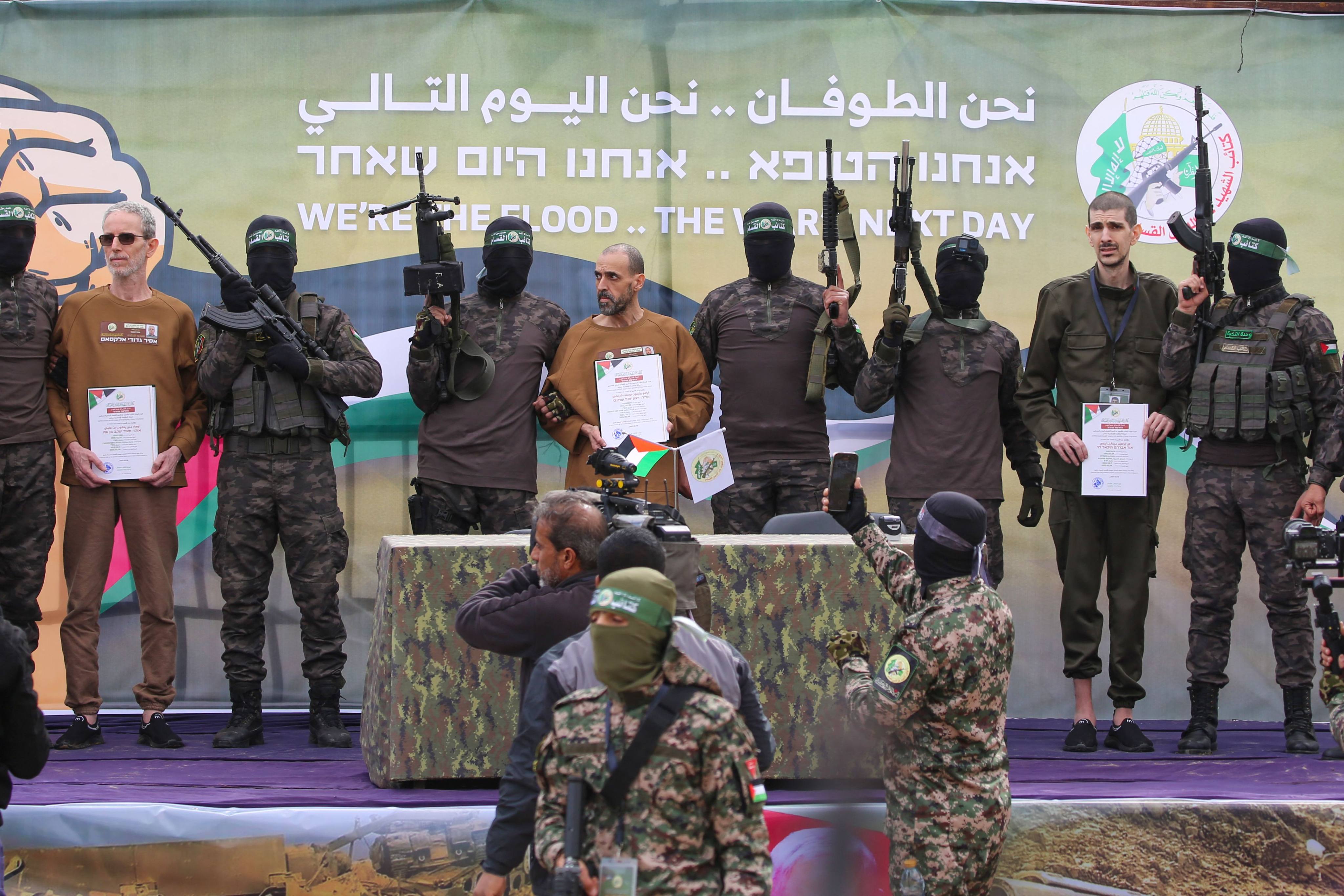 Hamas fighters escort Israeli hostages (left to right) Ohad Ben Ami, Or Levy and Eli Sharabi before handing them over to a Red Cross team in Deir el-Balah, central Gaza, on Saturday. Photo: AFP