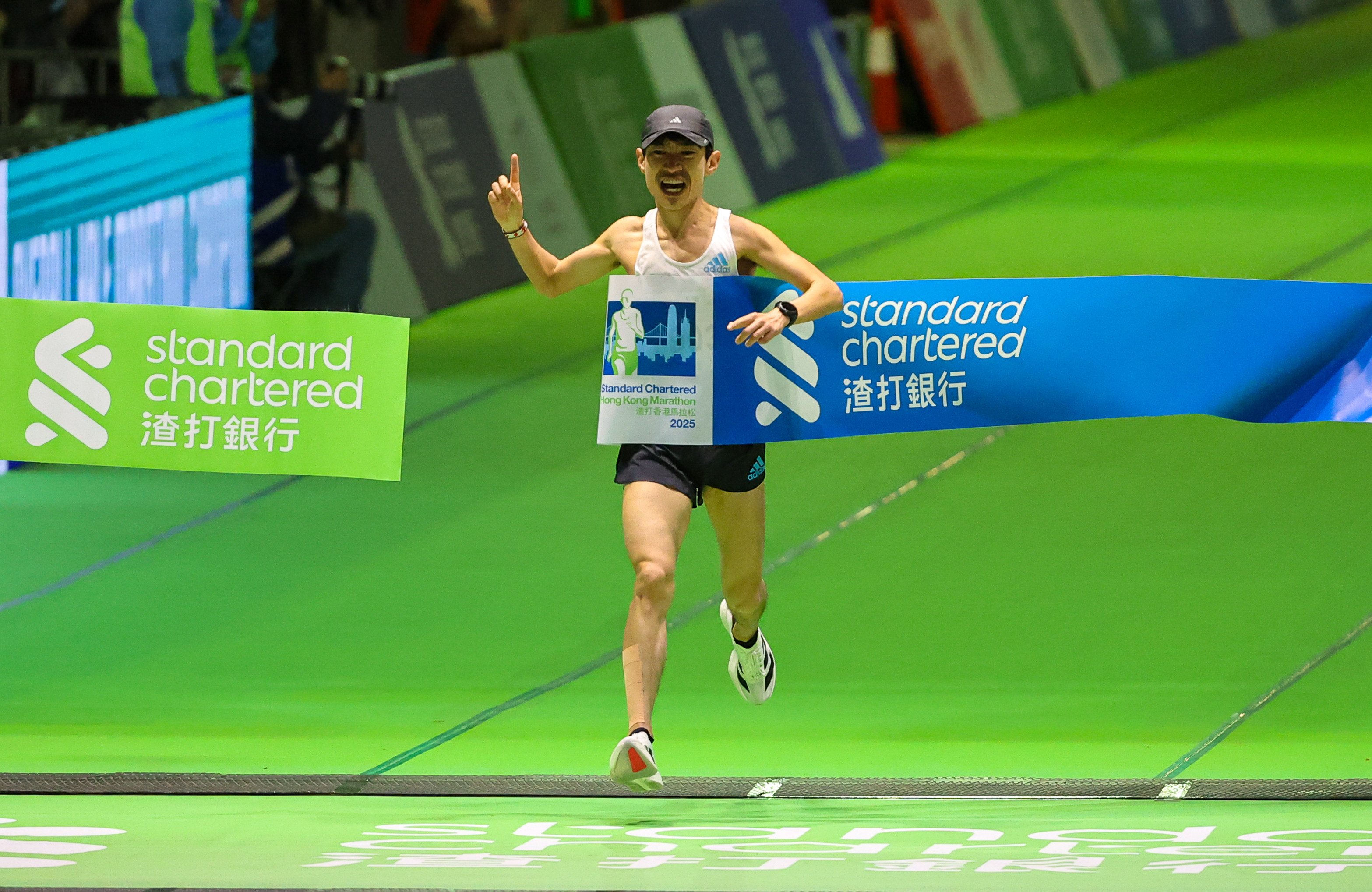 He Yingbing celebrates winning the half-marathon. He was disqualified soon after. Photo: Edmond So