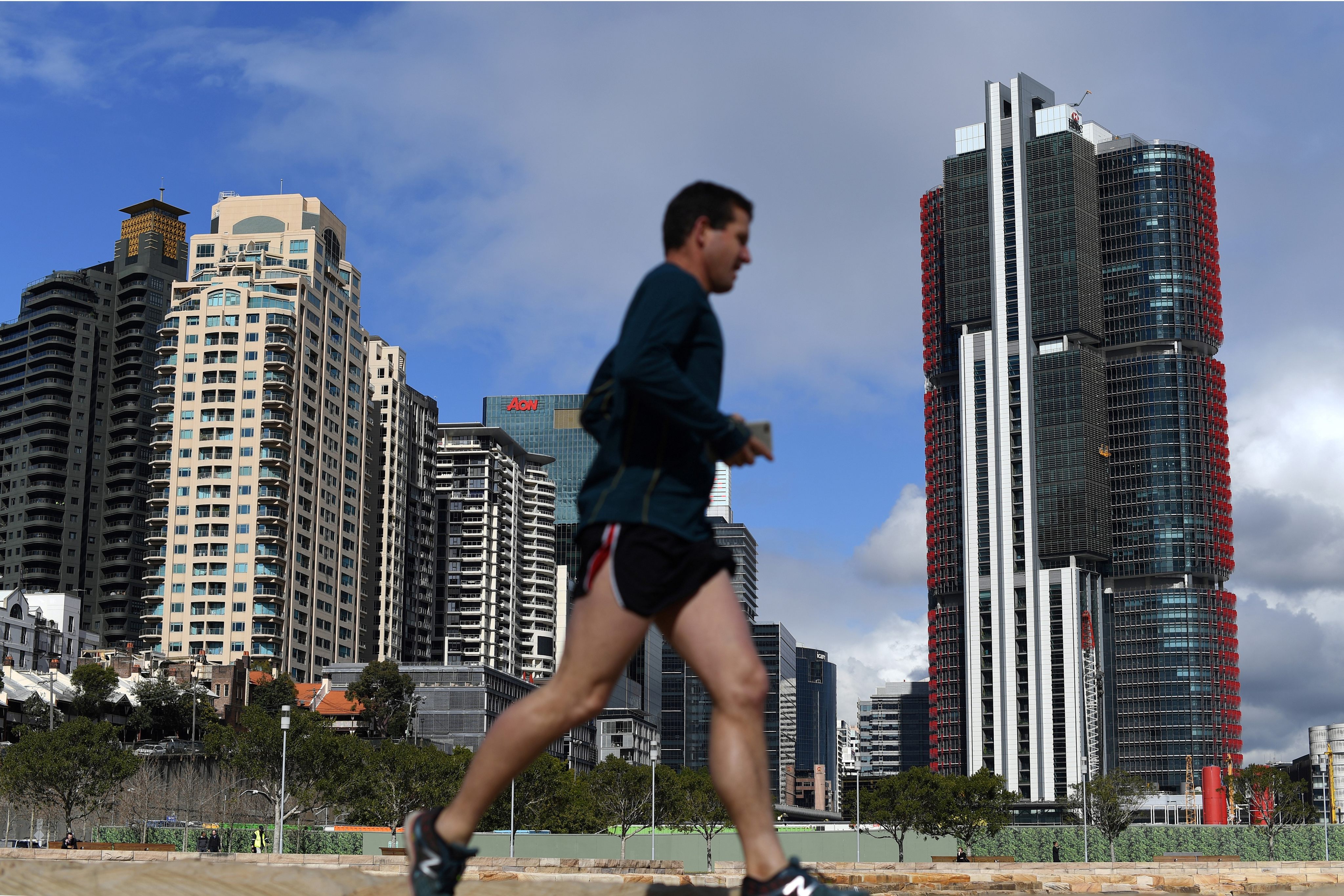 A man jogs past new developments in Sydney. Photo: AFP