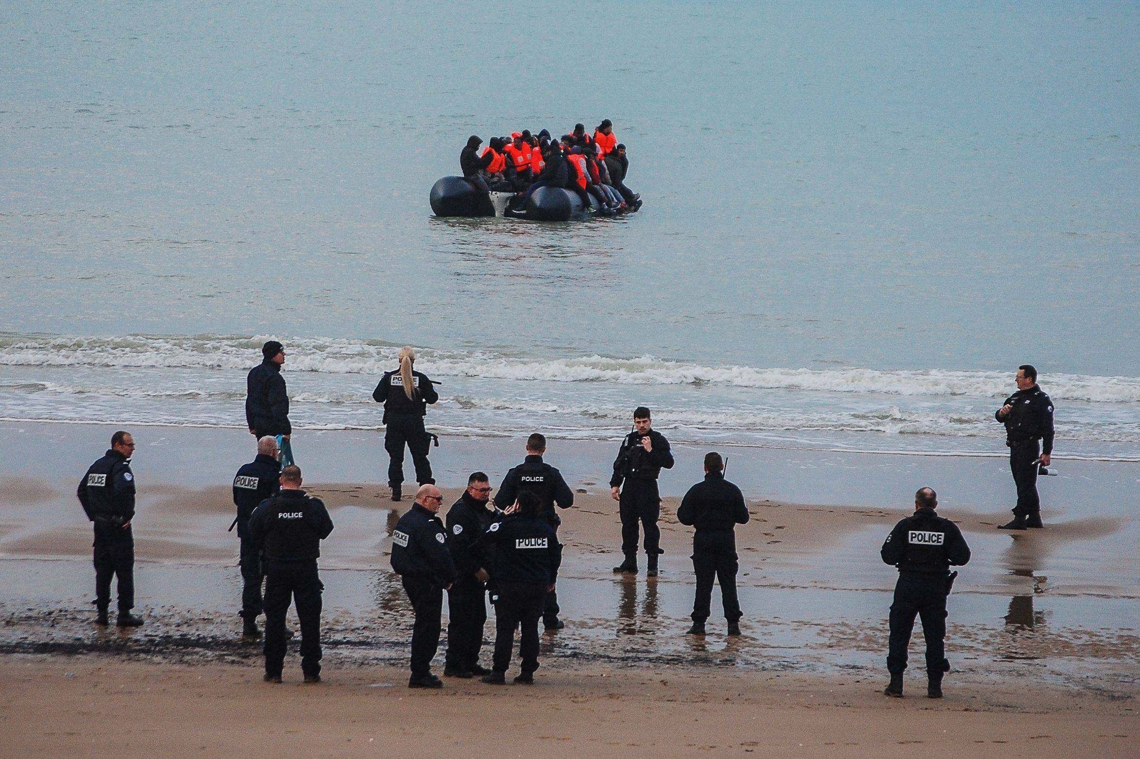 French officers stand on the shore as migrants attempt to cross the English Channel to reach the UK on a dinghy near Calais, northern France, on January 15. Photo: AFP