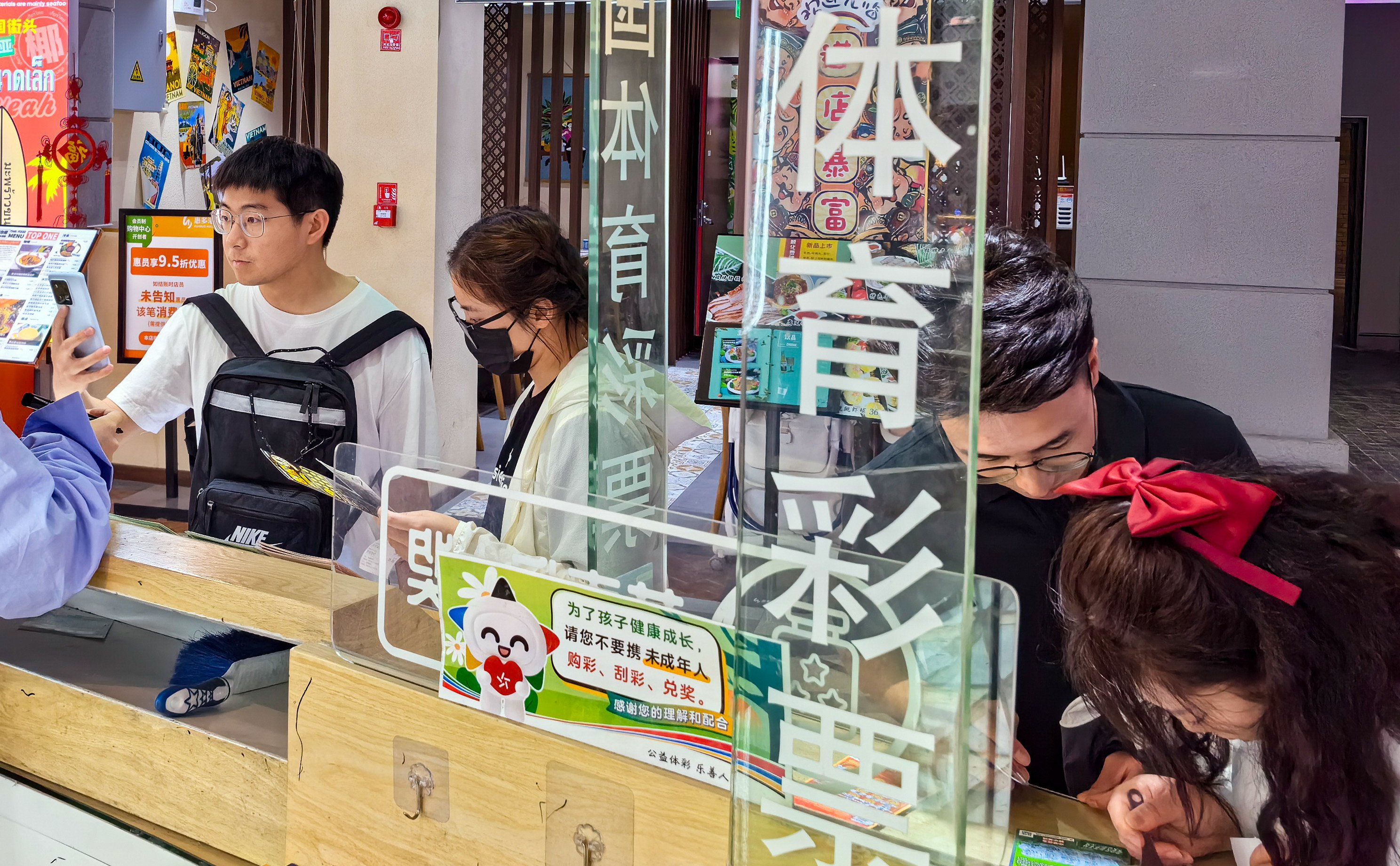 Young people play the lottery in Beijing last June. China’s annual lottery sales reached an all-time high in 2024. Photo: Simon Song