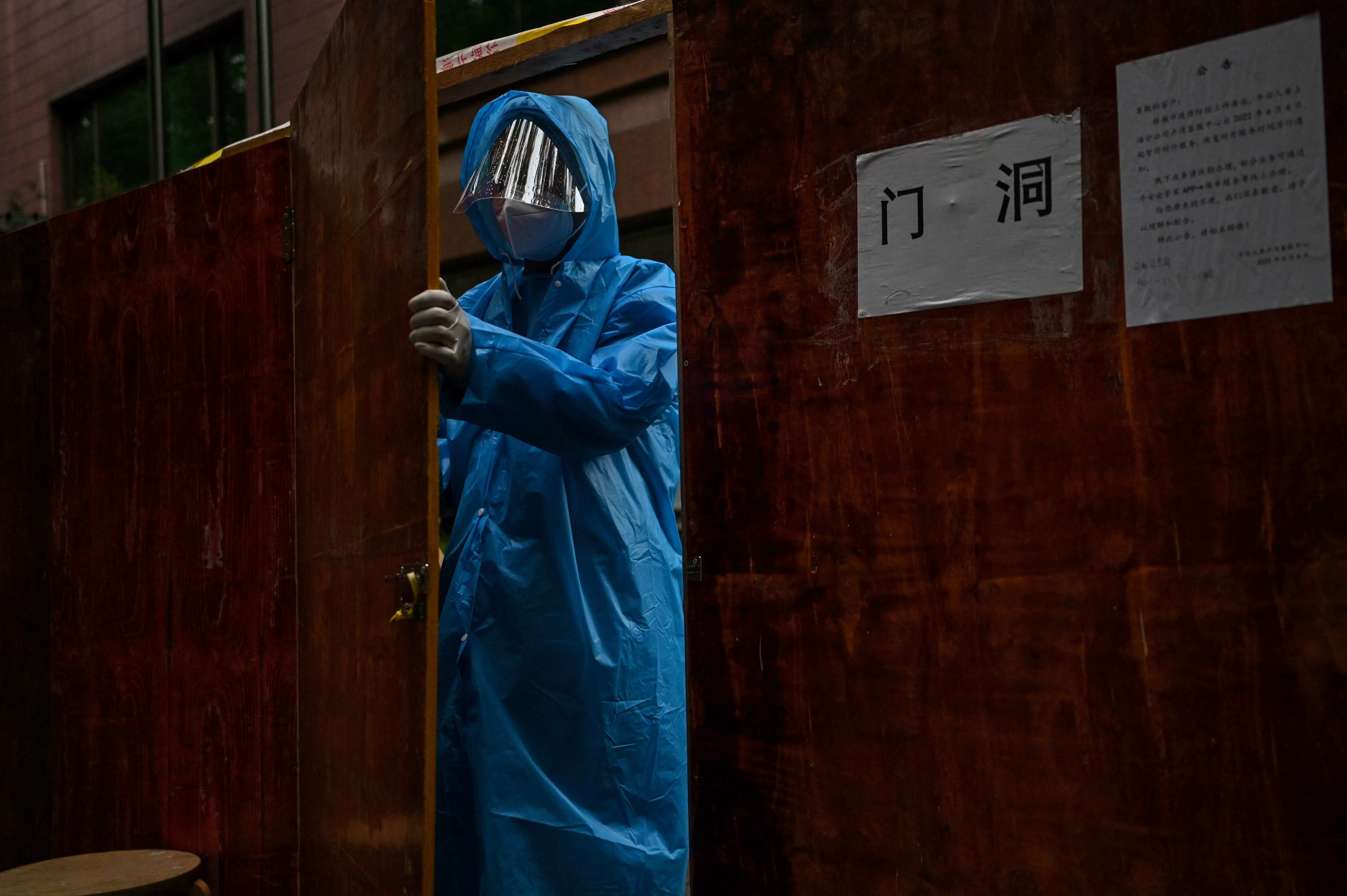 A worker prepares a fence to close off a residential area under Covid-19 lockdown in the Huangpu district of Shanghai in June 2022. Photo: AFP