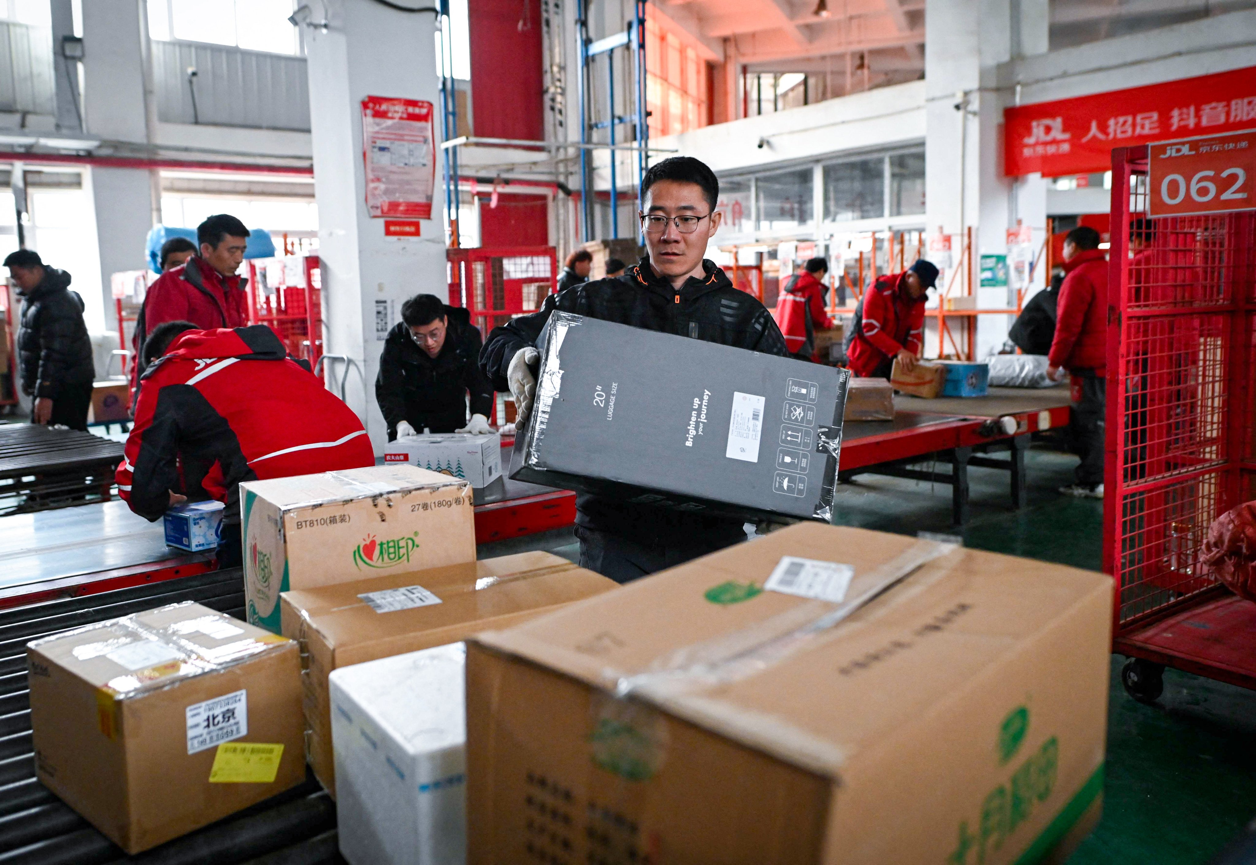 Workers sort packages for delivery at a JD.com warehouse in Beijing on November 11, 2024. Photo: AFP