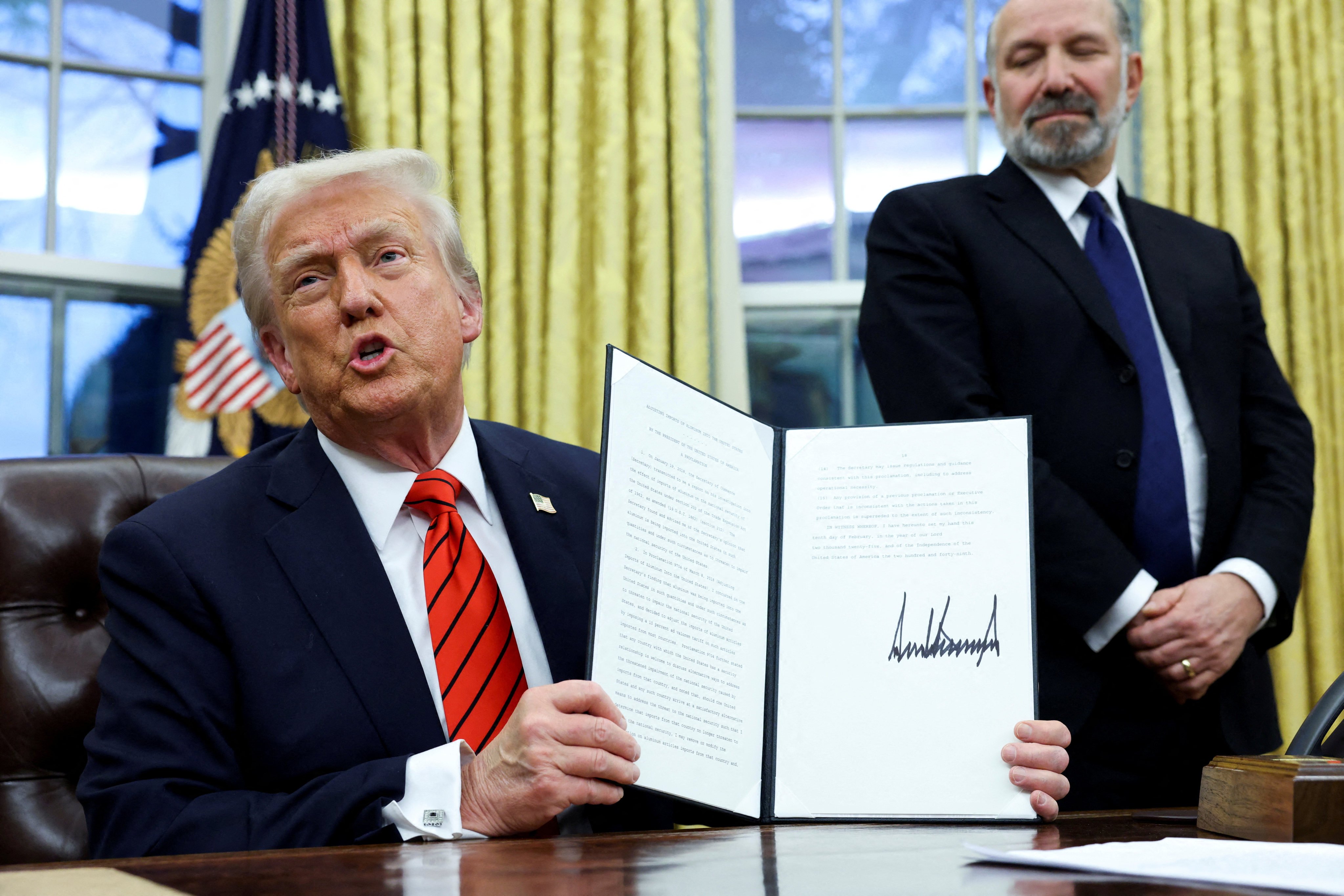 US President Donald Trump holds a signed executive order on tariffs on aluminium imports at the White House in Washington on Monday. Photo: Reuters