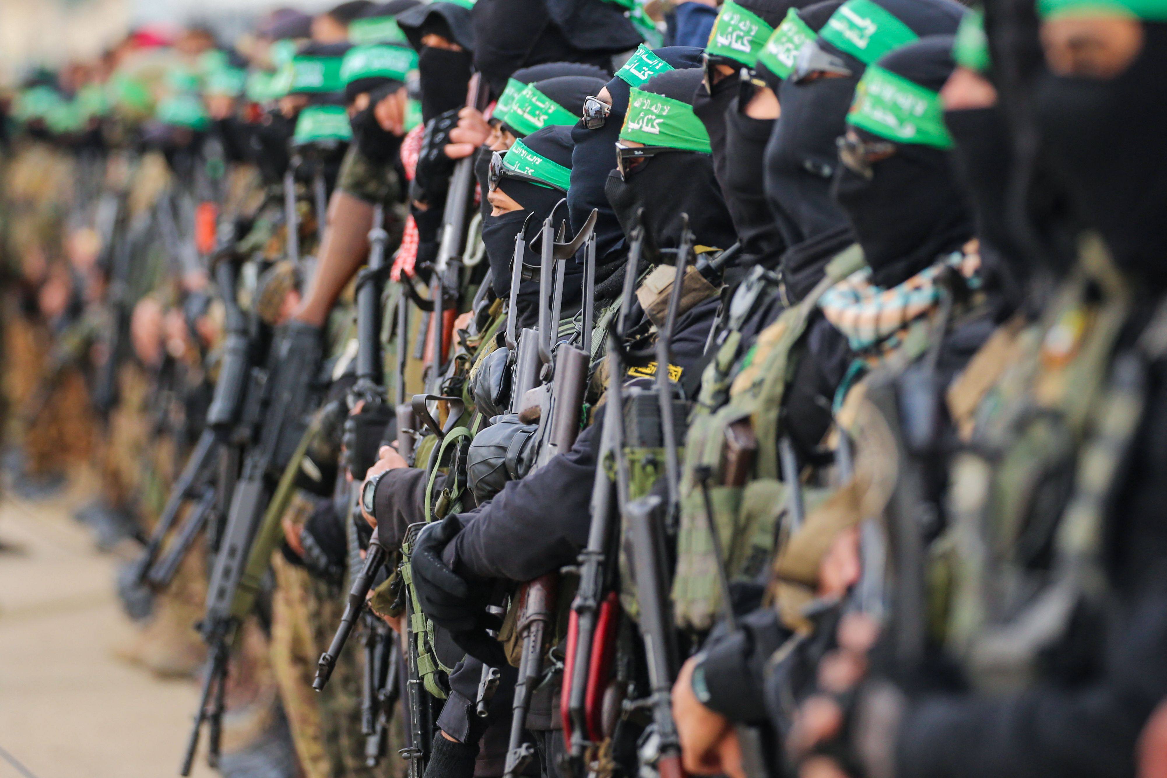 Hamas fighters secure an area before handing over three Israeli hostages to a Red Cross team in Deir el-Balah, central Gaza, on February 8. Photo: AFP