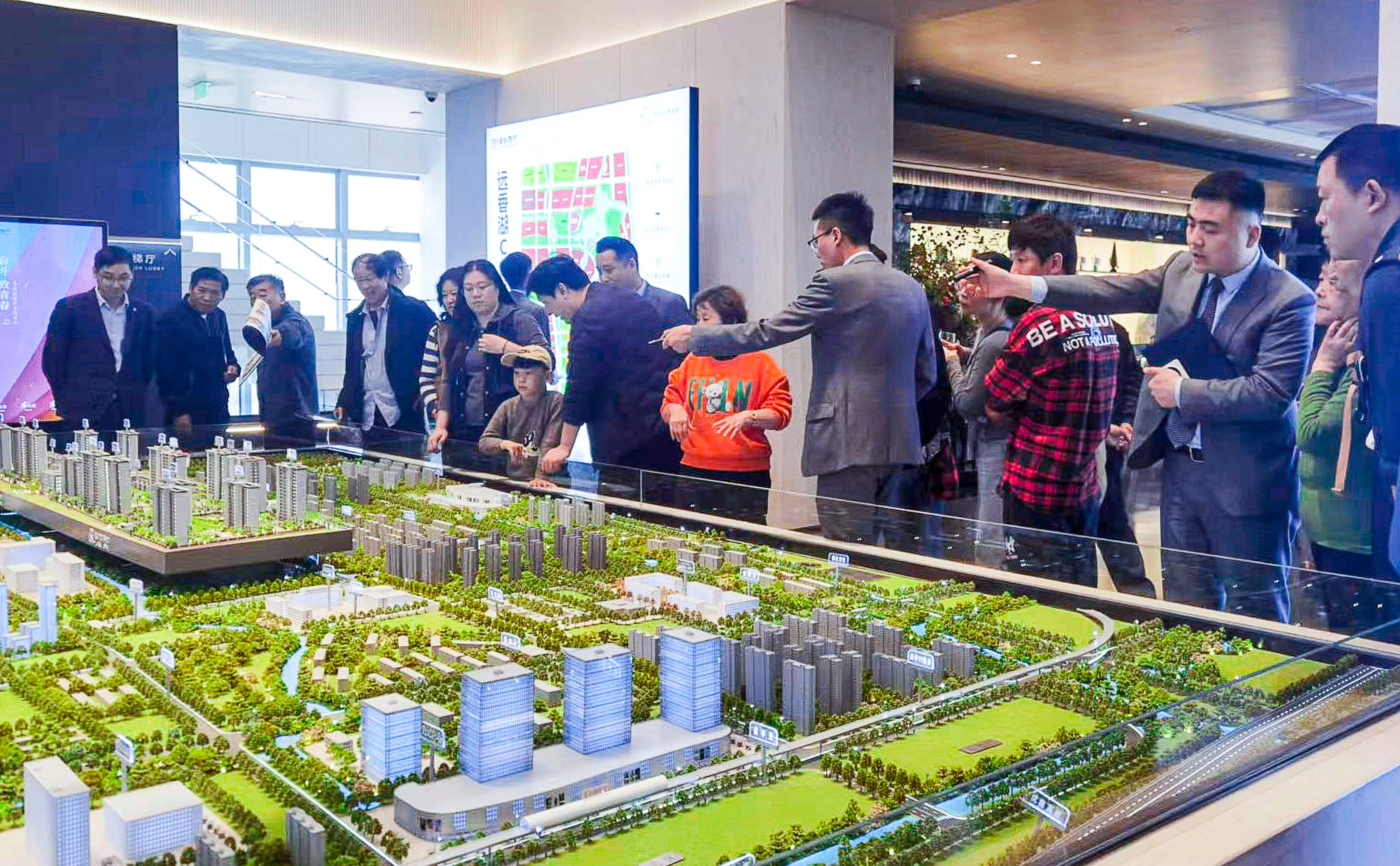 Property agents show potential buyers a model of a residential development in Shanghai on May 28, 2024. Photo: Xinhua