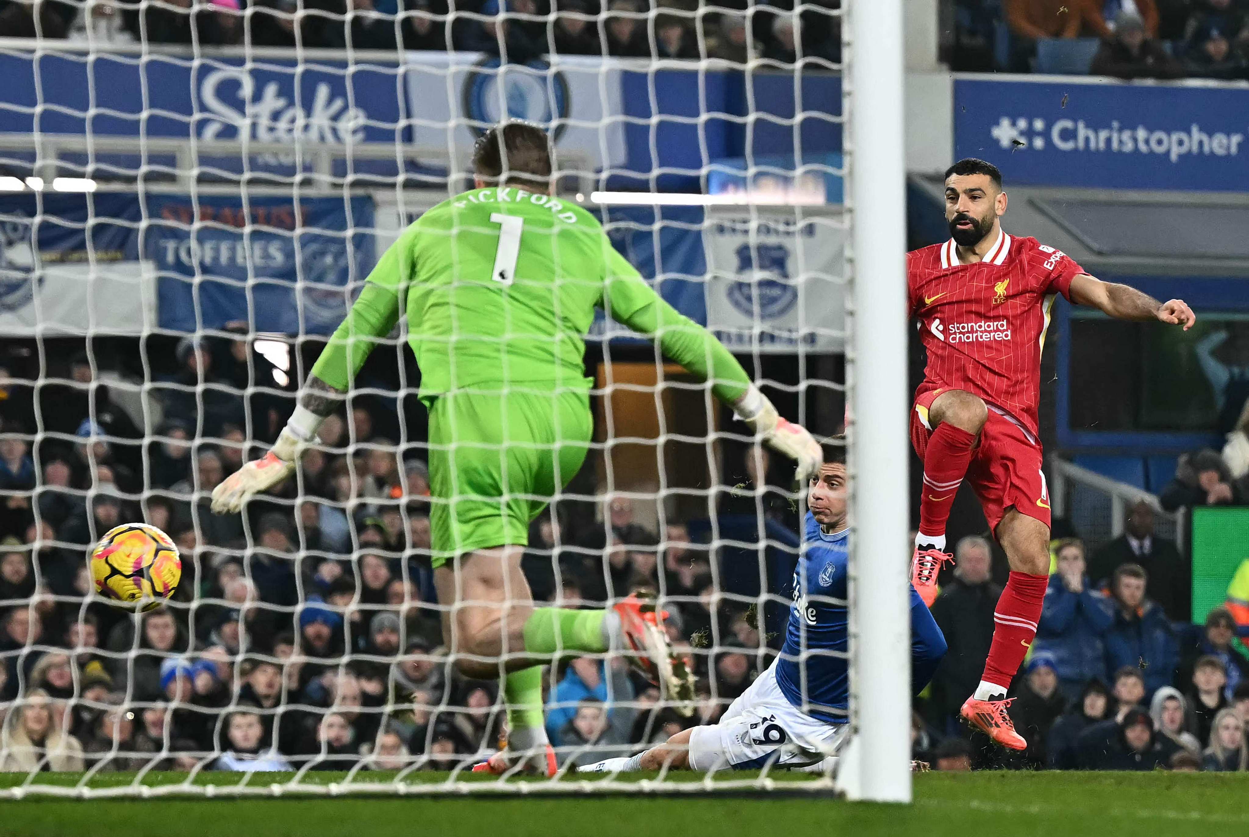 Liverpool’s Egyptian striker Mohamed Salah (right) scores his team’s second goal past Everton goalkeeper Jordan Pickford in their 2-2 draw at Goodison Park on Wednesday. Photo: AFP