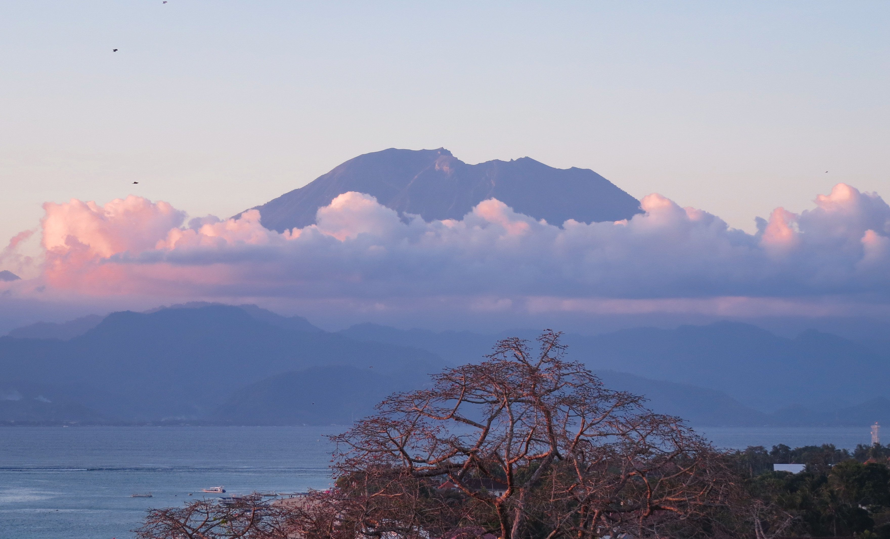 Northeast Bali’s sacred volcano, Mount Agung, casting a sunset glow over Jungut Batu, directly opposite. Photo: Deborah Cassrels