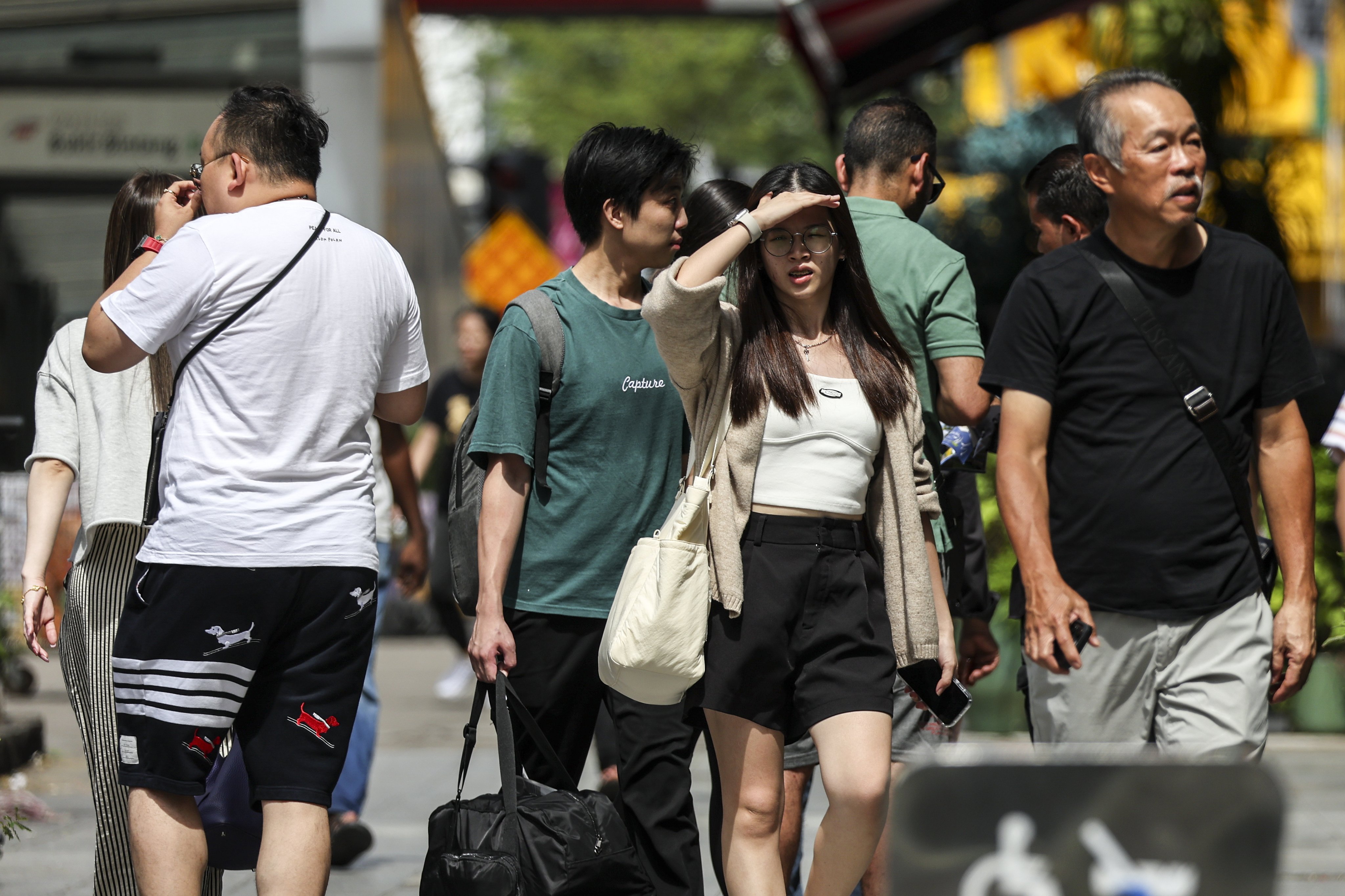 People walk in the street in Kuala Lumpur. Malaysia’s government is facing a backlash for terminating 30,000 contract staff without a school-leaving certificate. Photo: EPA-EFE