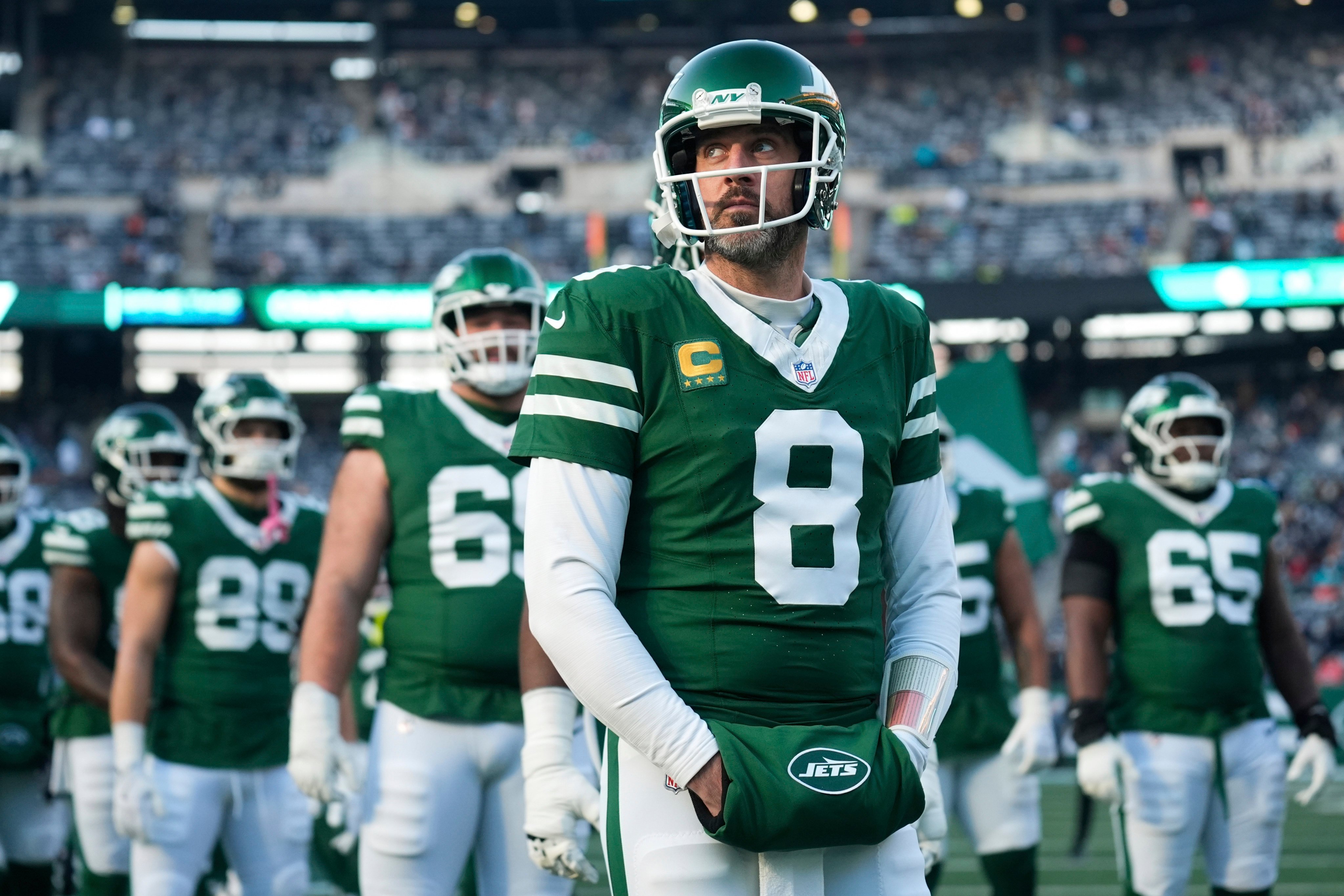 New York Jets quarterback Aaron Rodgers (8) stands with teammates before an NFL game against the Miami Dolphins in January. Photo: AP