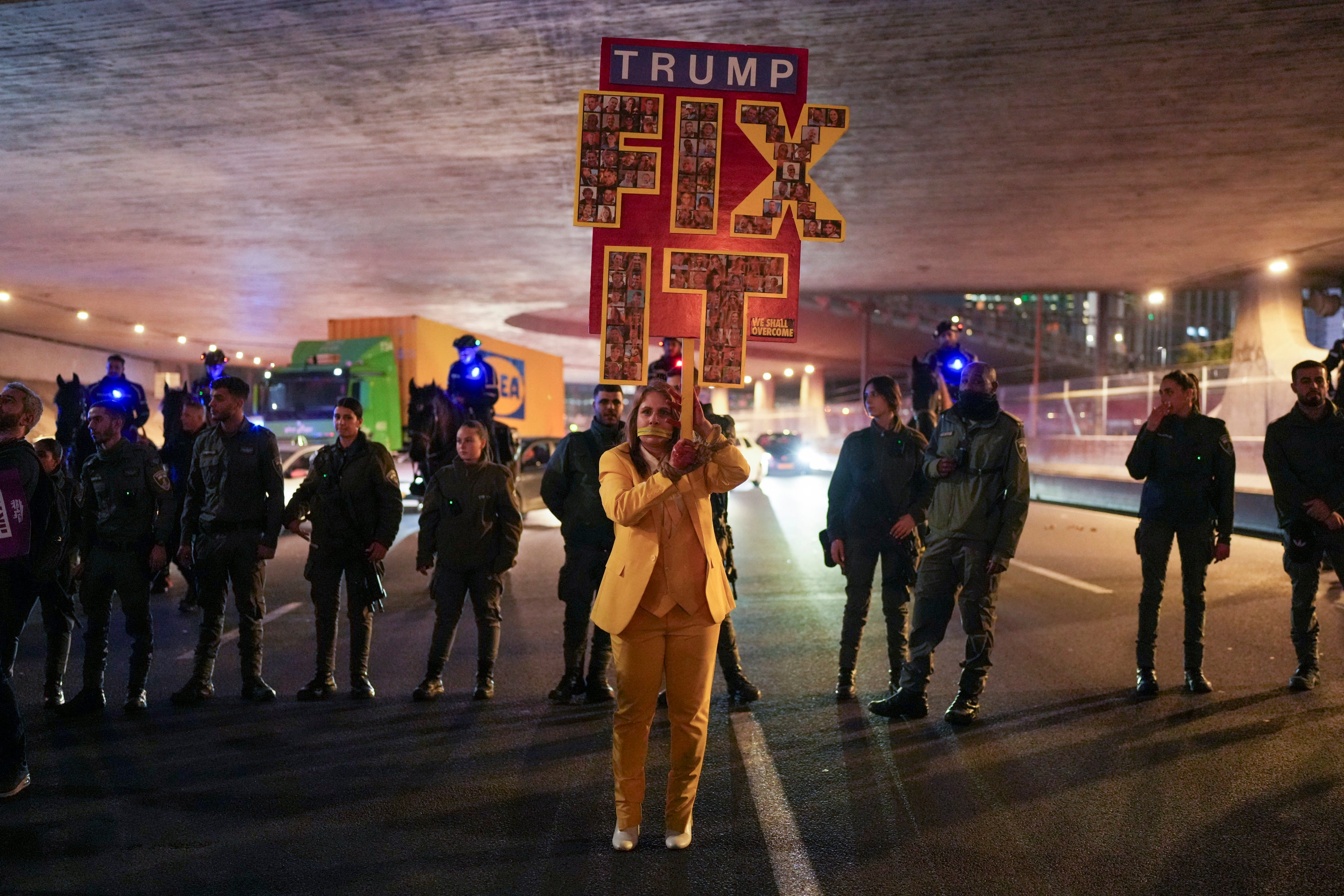 A protester holds a sign on a highway in Tel Aviv, Israel, on Monday after Hamas said it would delay a planned hostage release. Photo: AP