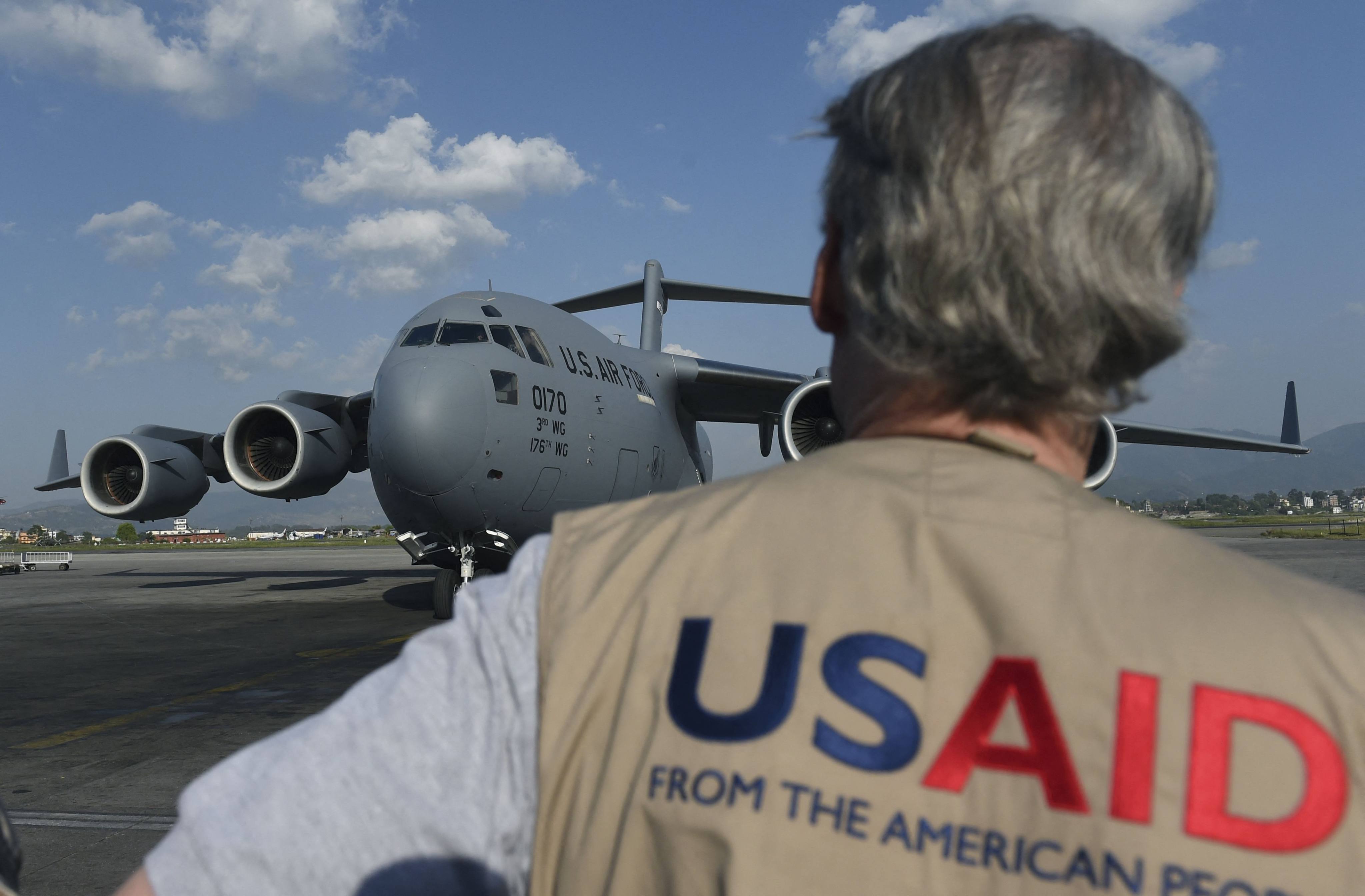 A USAID officer watches as a US military cargo plane taxis to a stop at an airport in Kathmandu, Nepal, in 2015. Photo: AFP