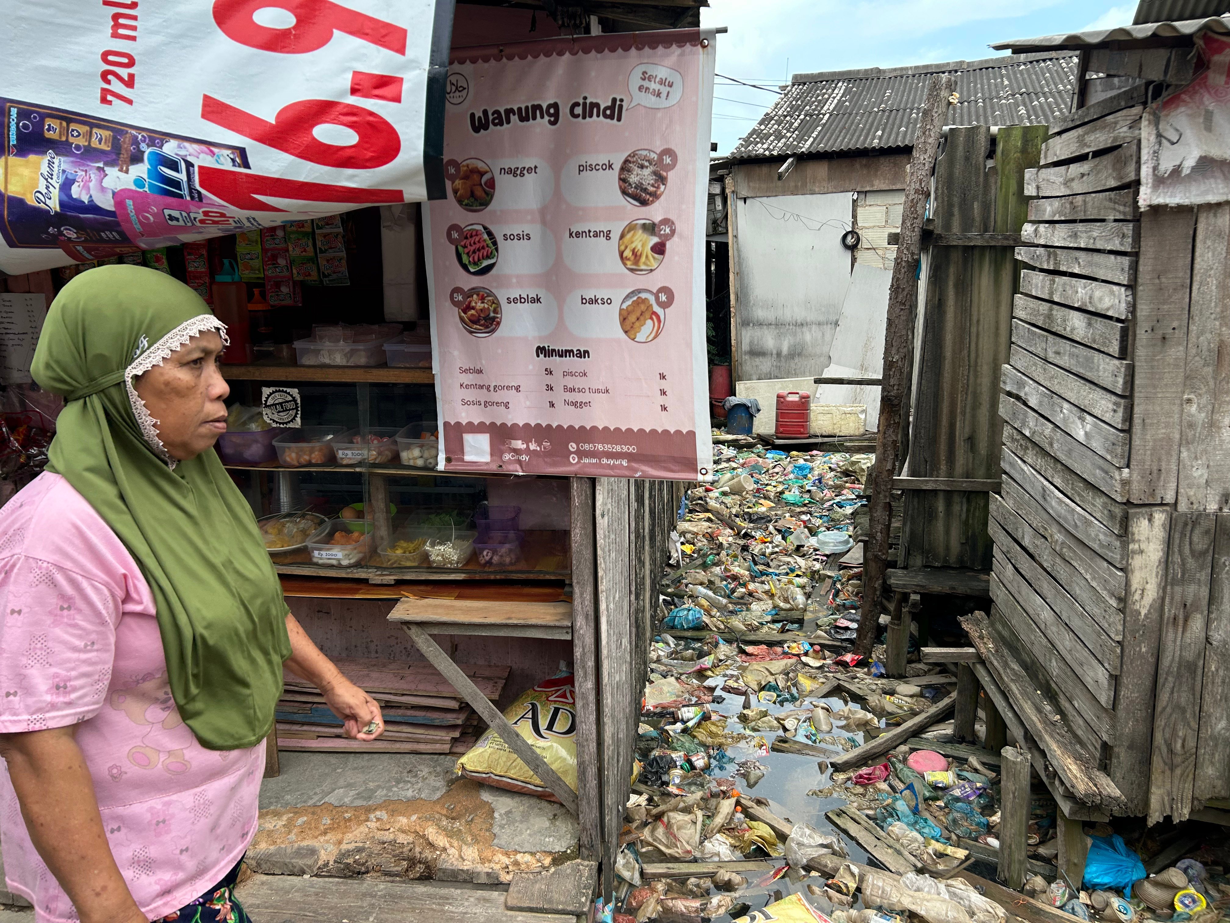 A food stall in Tanjung Uma next to a trash-strewn waterway. Photo: Ken Kwek