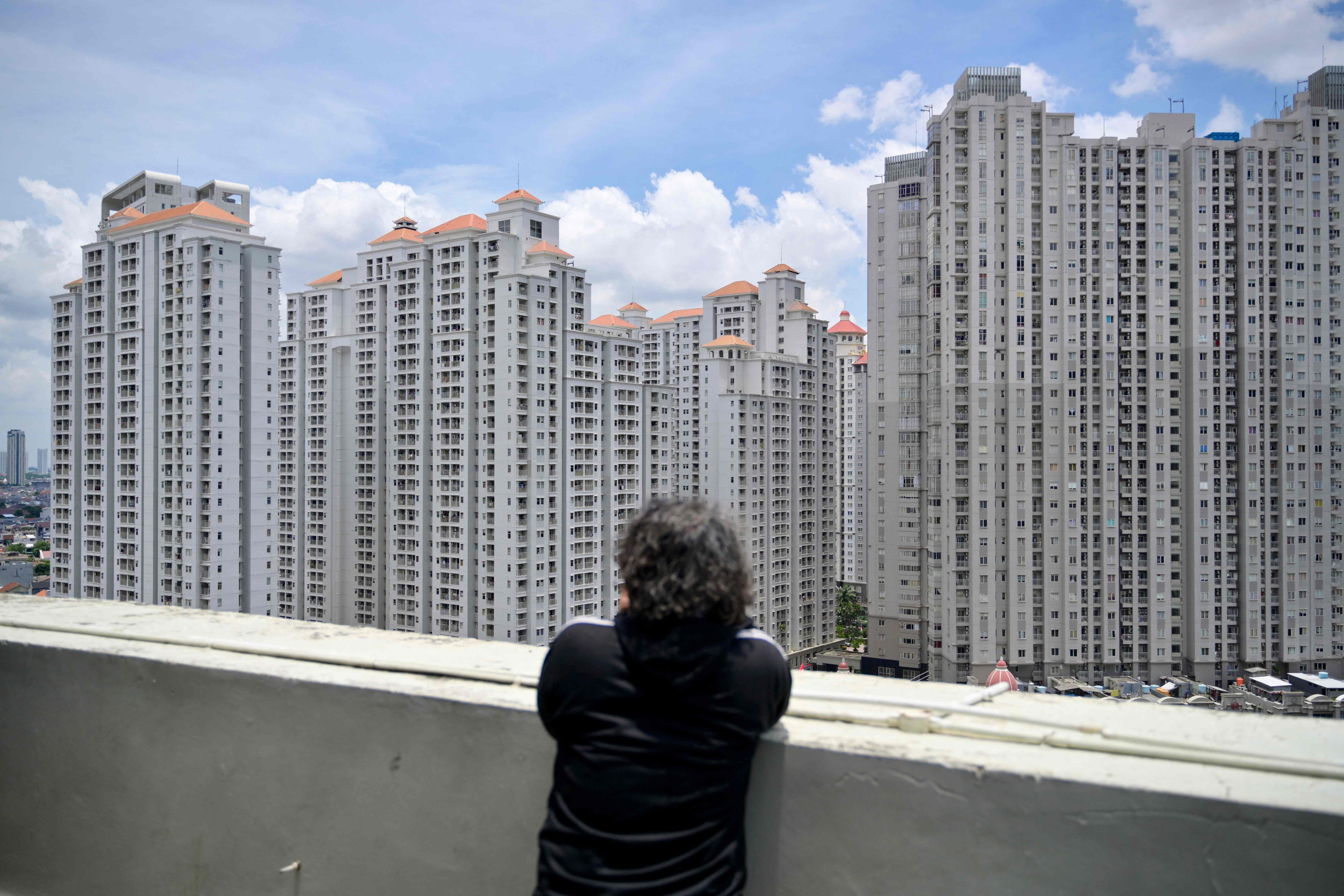 A man looks at residential buildings in Jakarta. Photo: AFP