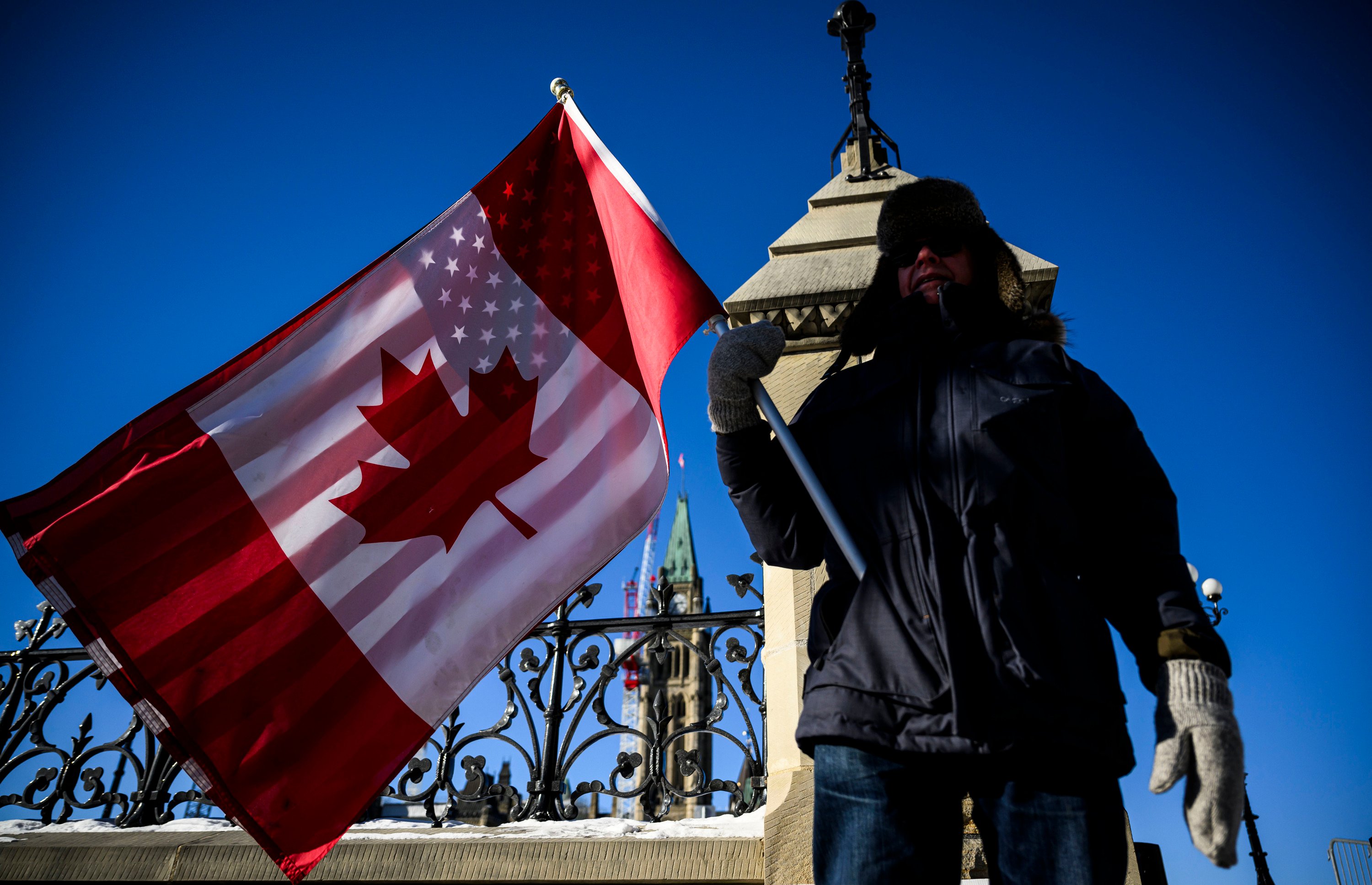 A protester holds Canadian and US flags on Parliament Hill in Ottawa on February 1. Photo: Canadian Press via AP