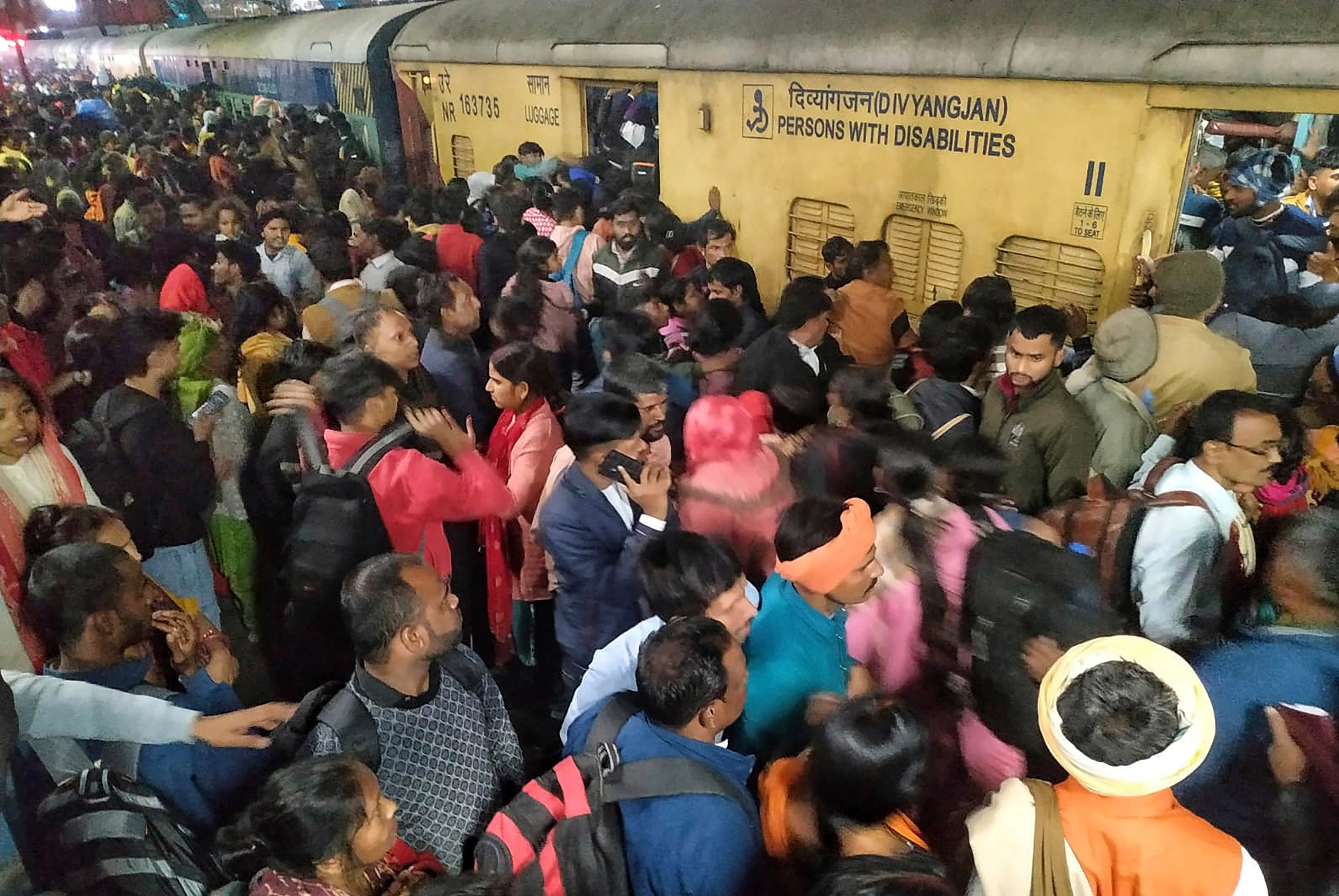 Passengers jostle with each other to board a train at New Delhi Railway station on Saturday. Photo: AP