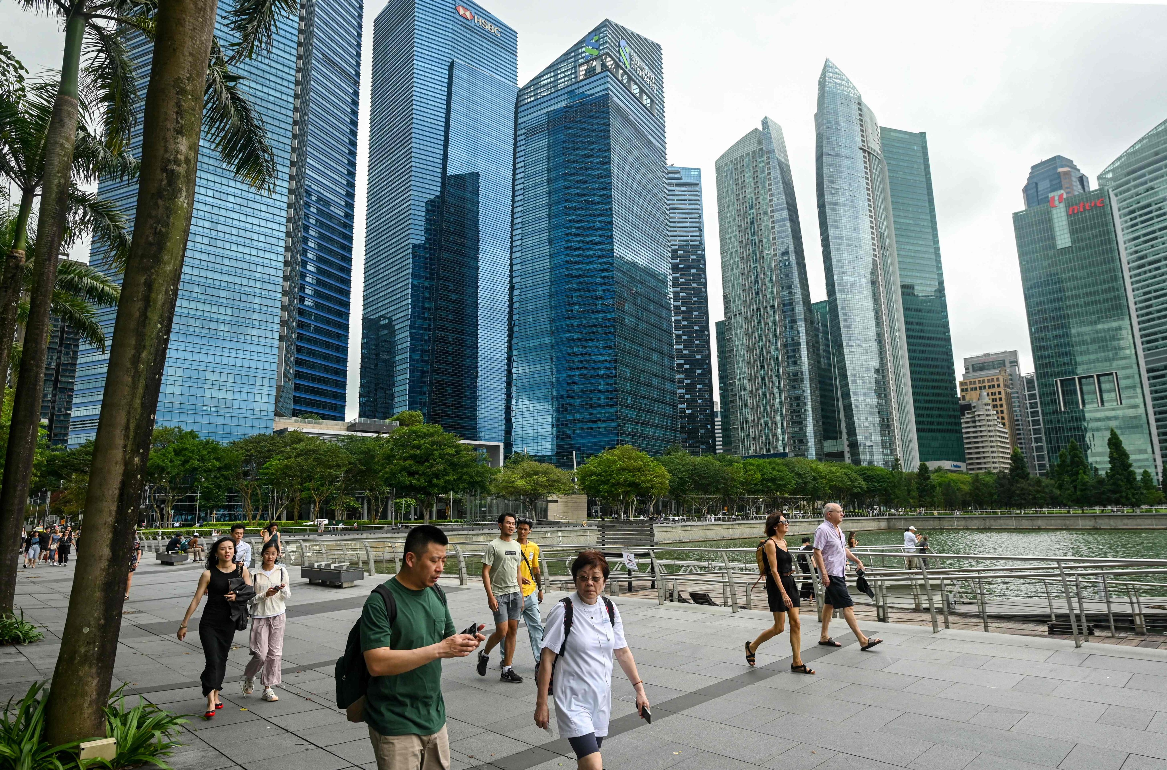 People walk along the promenade at Marina Bay in Singapore in January. The city state will unveil its budget on Tuesday. Photo: AFP