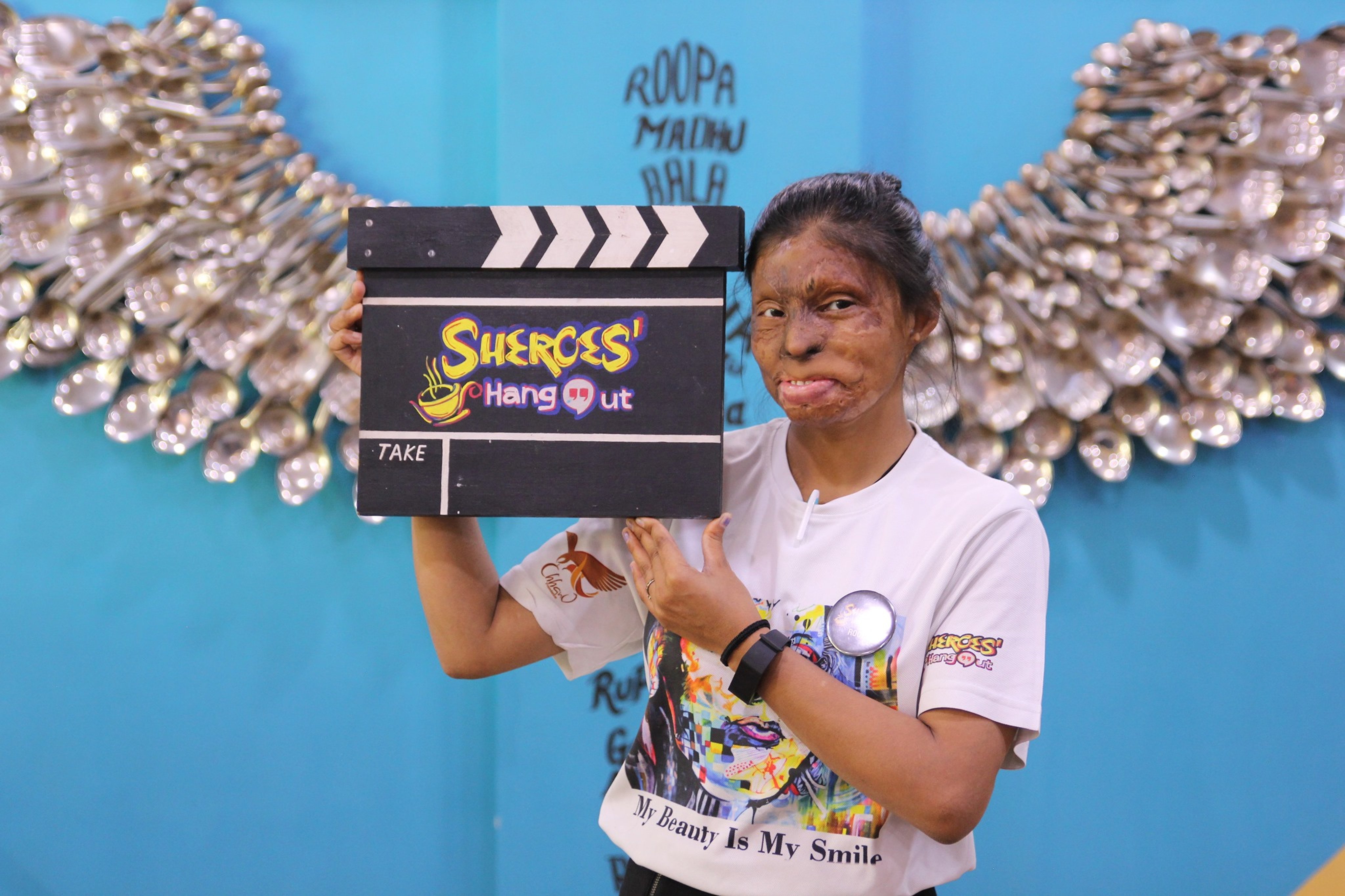 An employee of Sheroes Hangout holds a sign with the cafe’s name on it. Three Sheroes Hangout cafes in India’s Uttar Pradesh state employ about 50 victims of acid attacks. Photo: Facebook/Sheroes Hangout