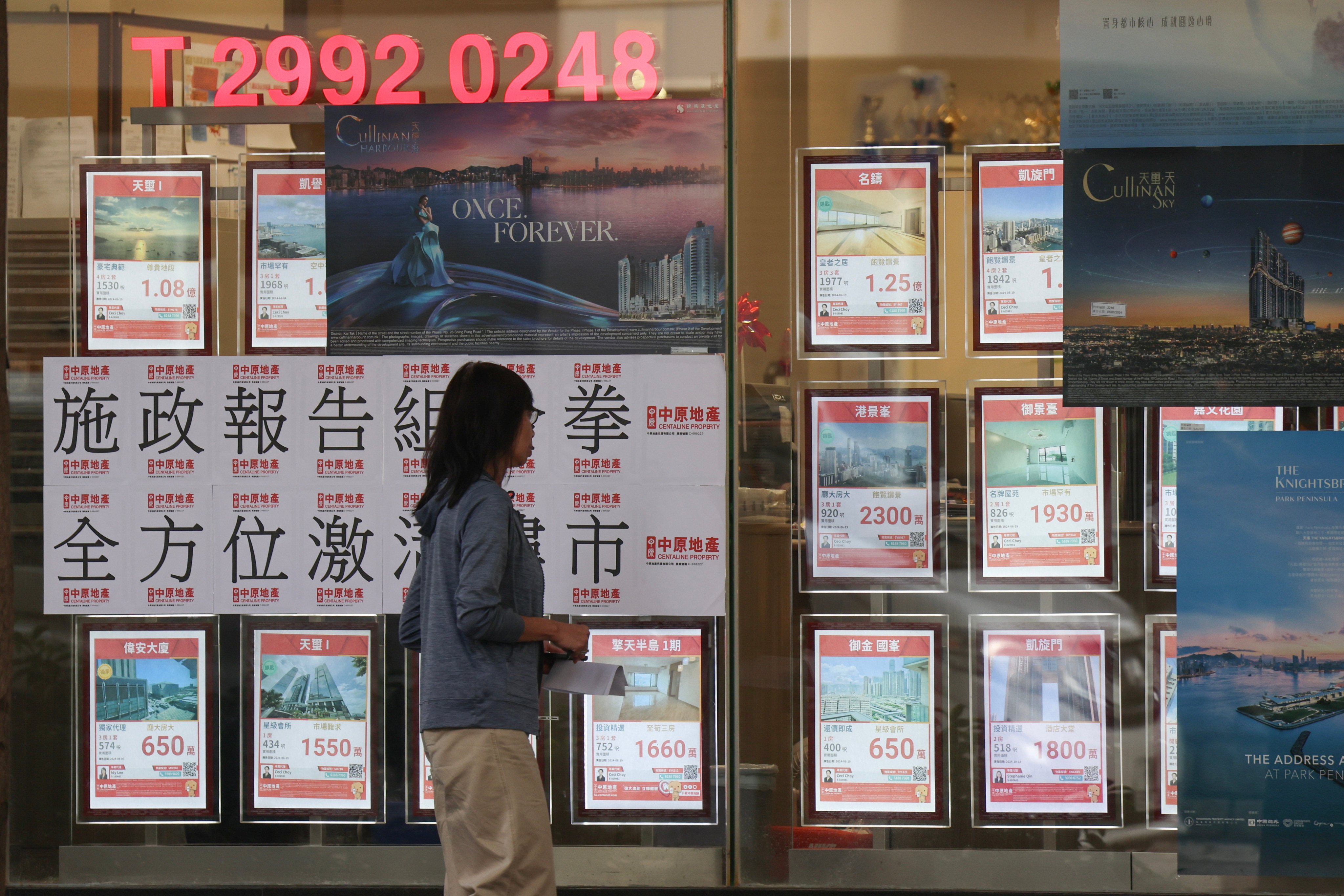 A woman passed a property agency in Jordan. Photo: Jelly Tse