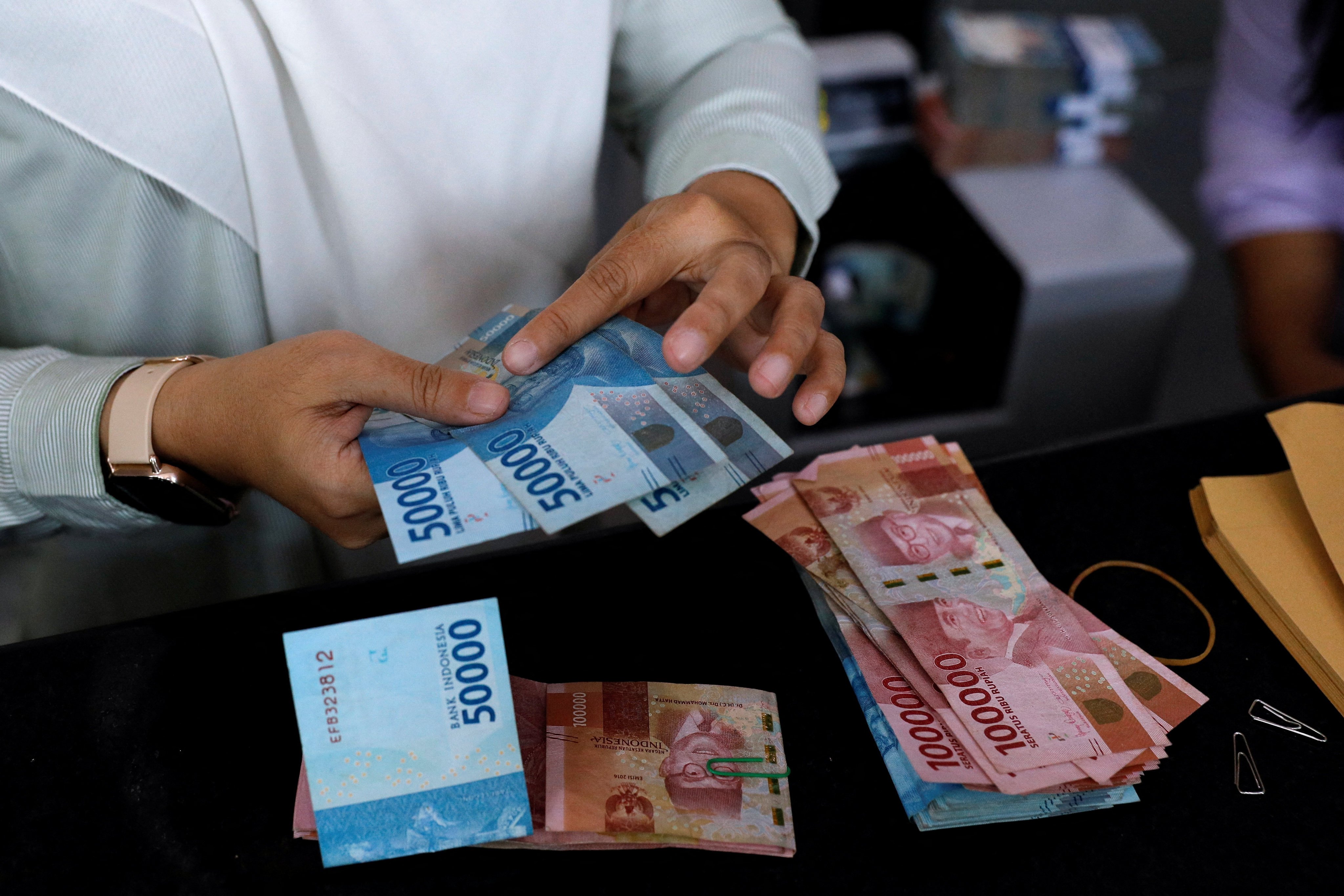 A teller counts Indonesian rupiah bank notes in Jakarta, Indonesia, in October 2022. Photo: Reuters