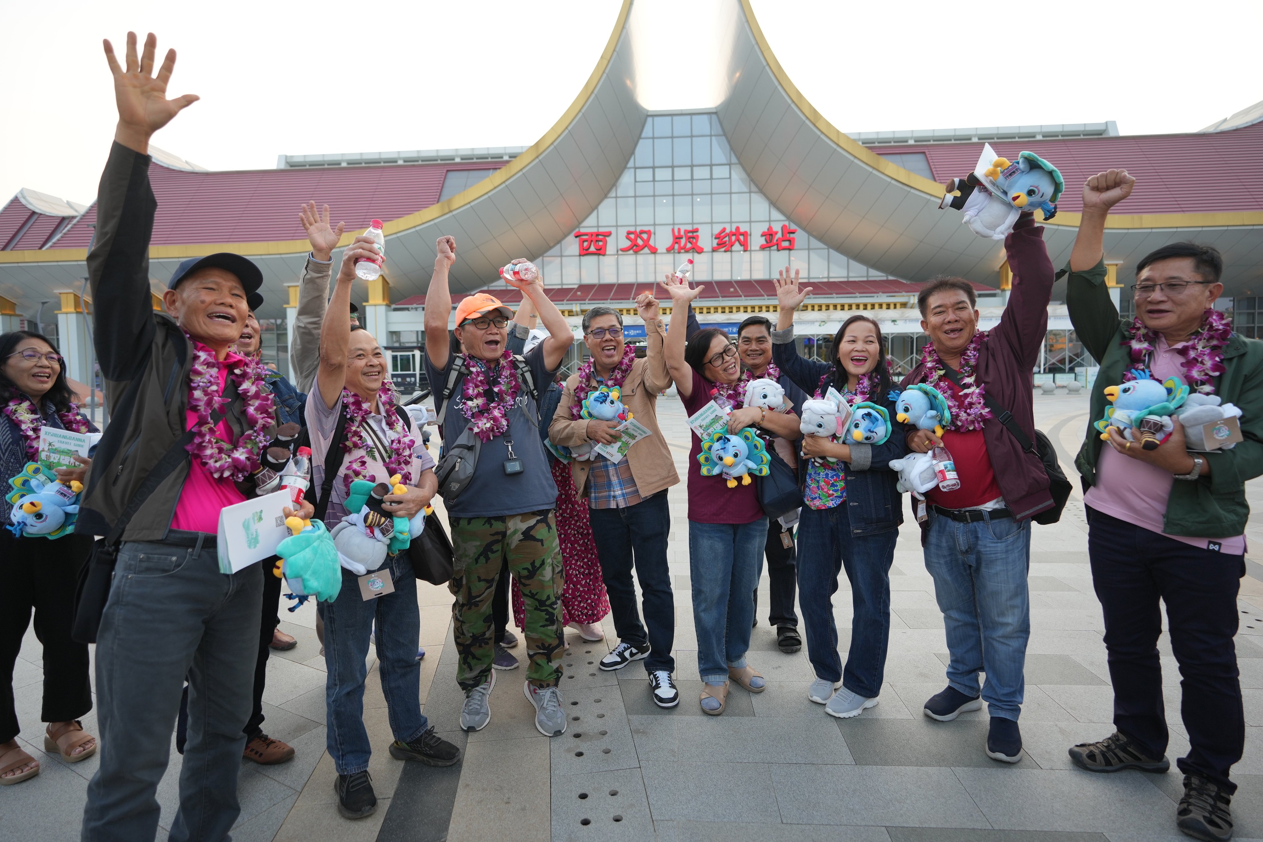 Tourists from Laos and Thailand pose for photos in front of Xishuangbanna Railway Station in Jinghong, southwest China’s Yunnan province, on February 18. Photo: Xinhua