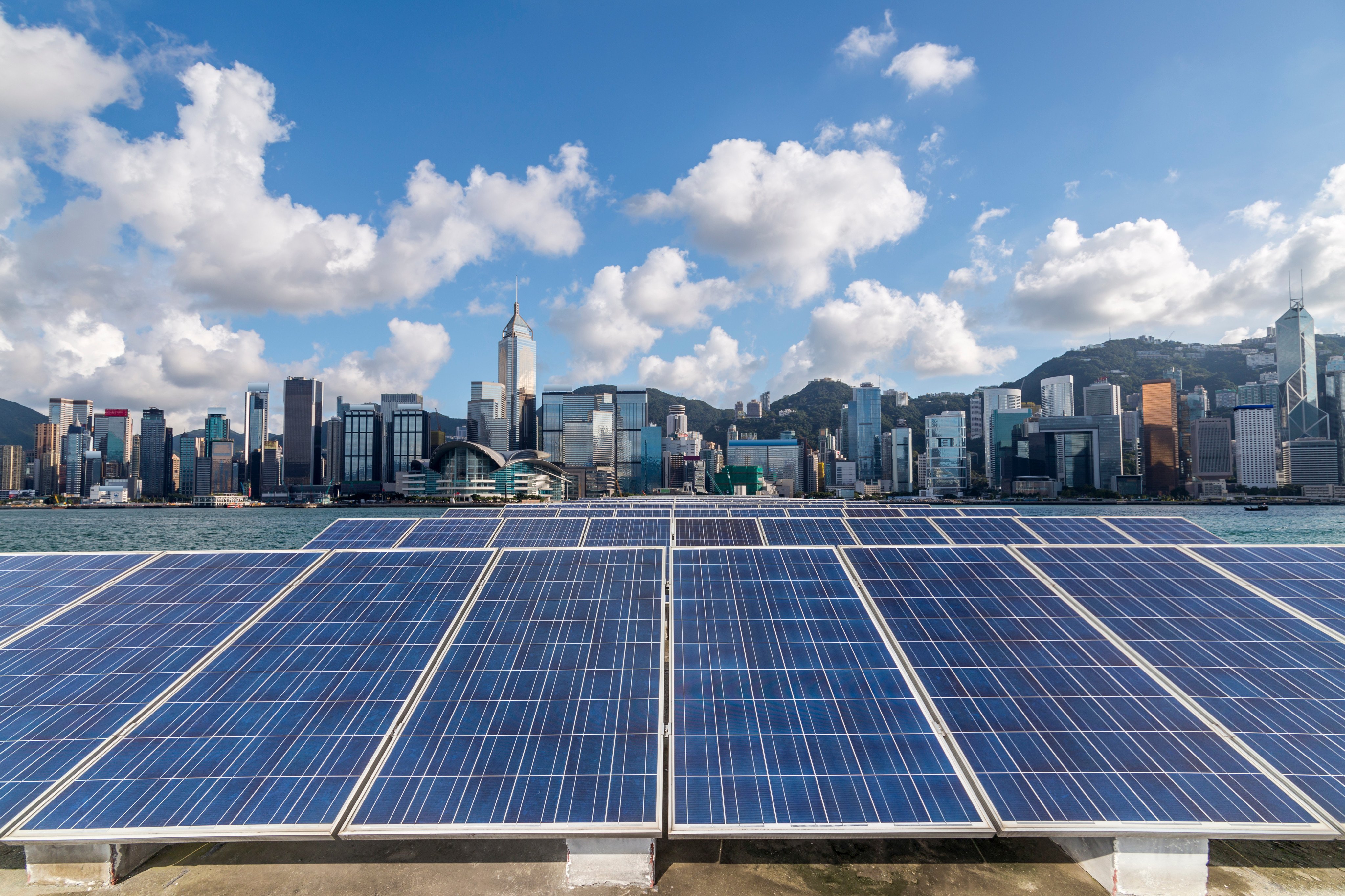 Solar panels are seen before the island-side skyline of Hong Kong. Photo: Shutterstock