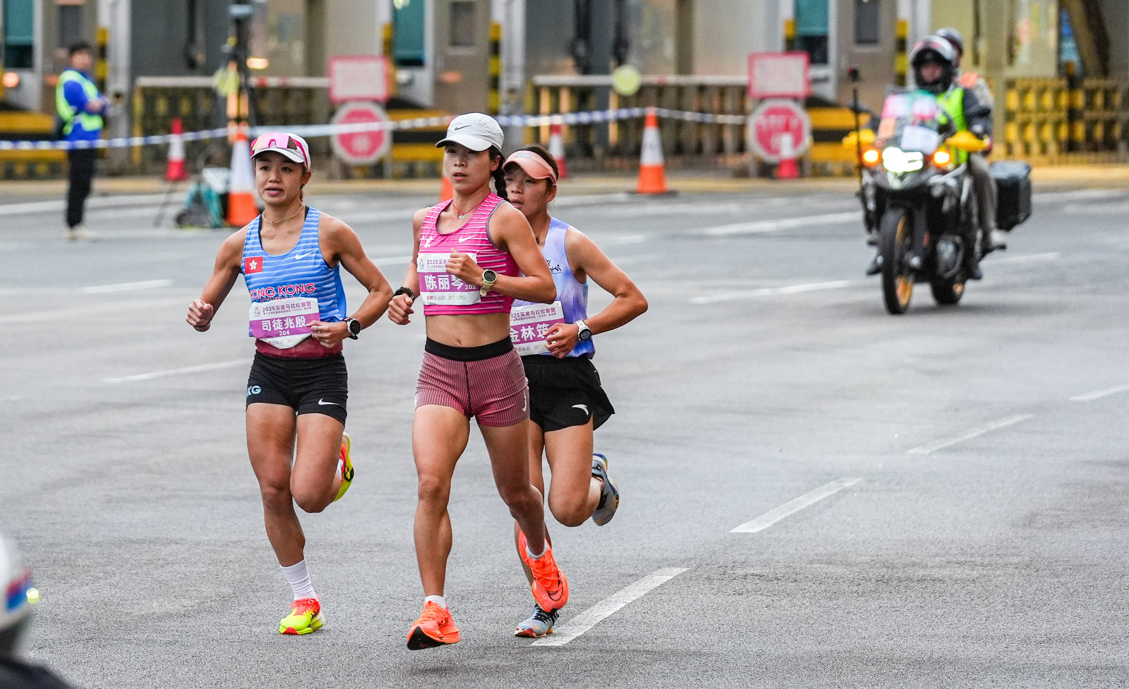 Leanne Szeto (left) runs the past Shenzhen Bay Control Point during the National Games marathon test event on Sunday. Photo: Eugene Lee