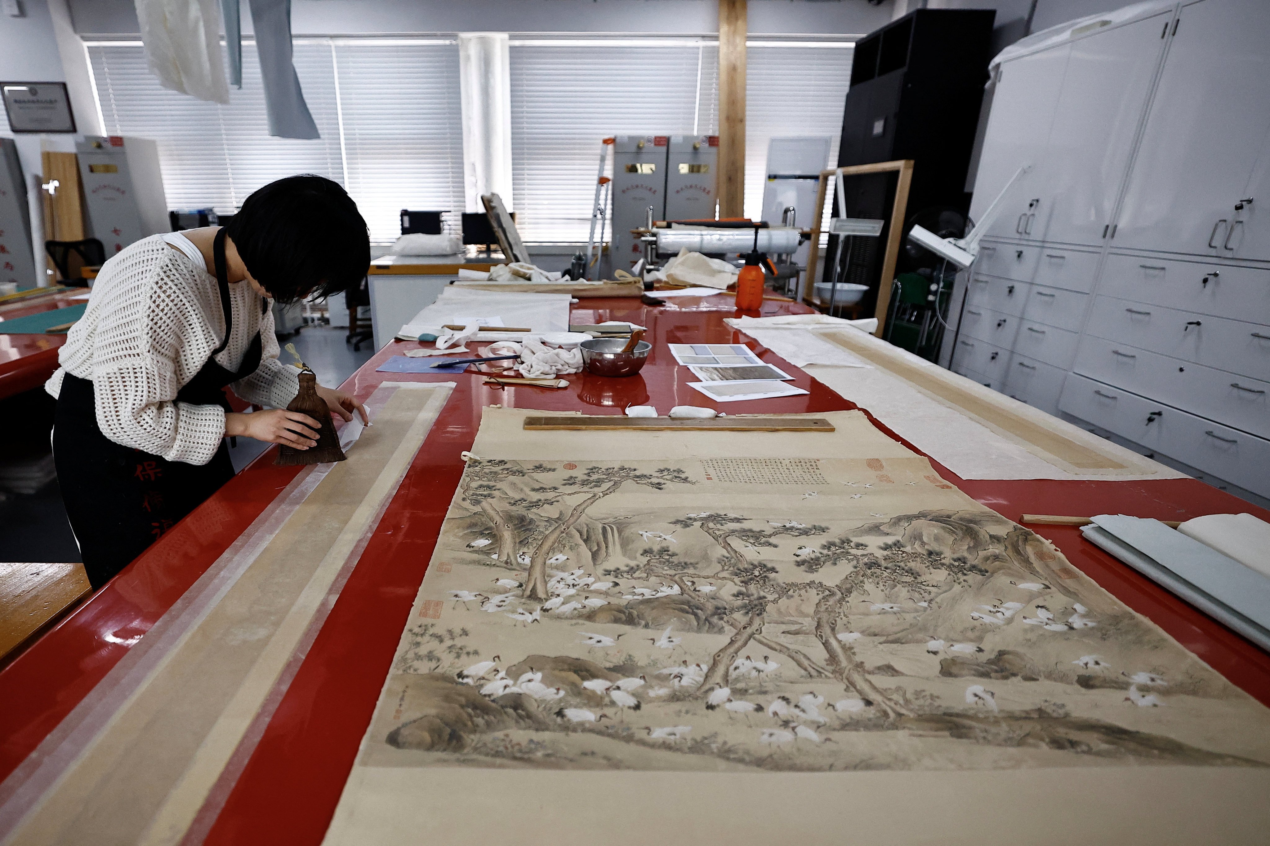 A conservator restores a scroll at the Palace Museum in Beijing. Photo: Reuters