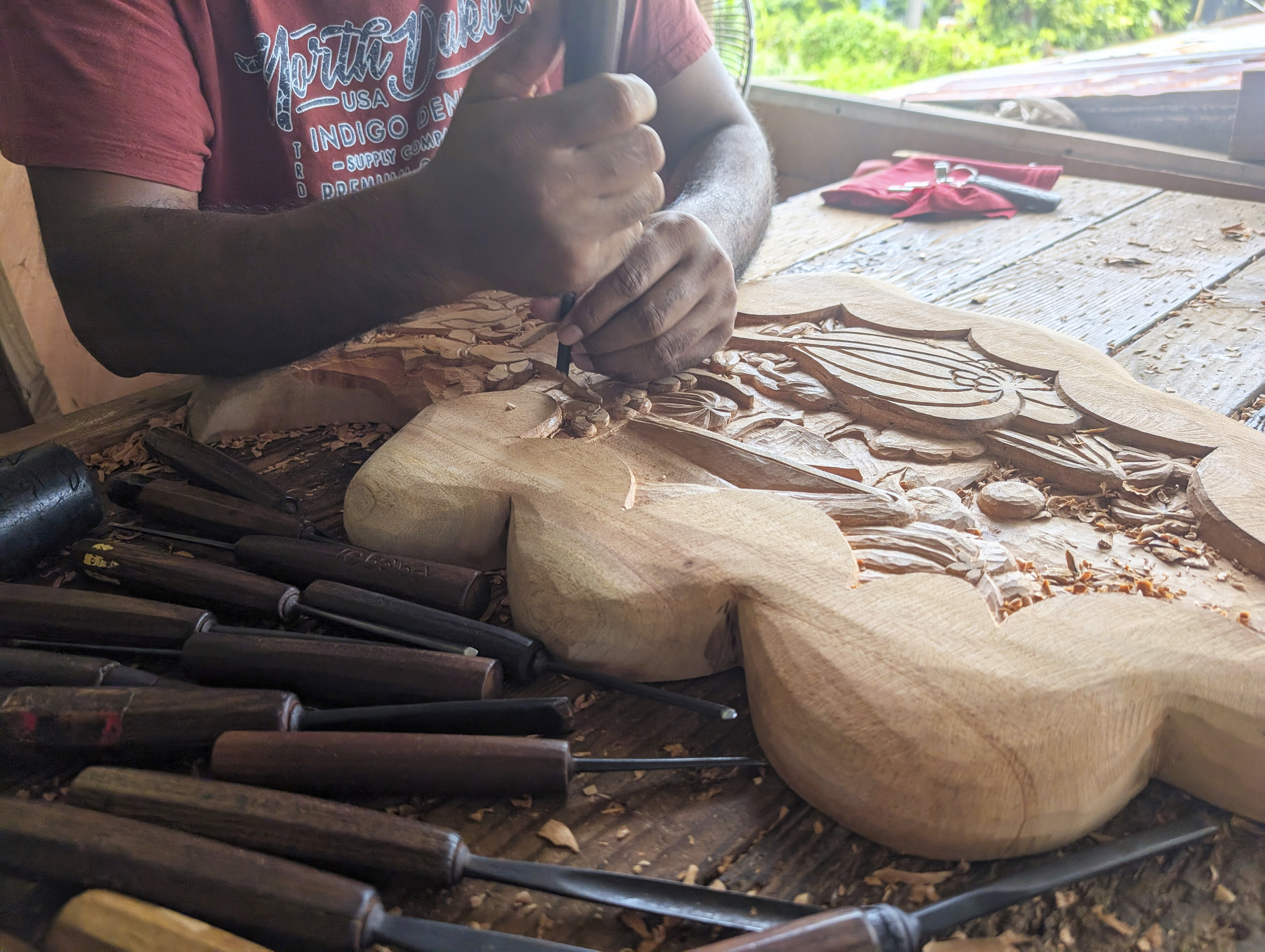 A woodcarver crafts a traditional storyboard, an intricately designed piece of art that illustrates Palau’s history and legends, at Tebang Woodcarving Shop in Koror, Palau. Photo: AP