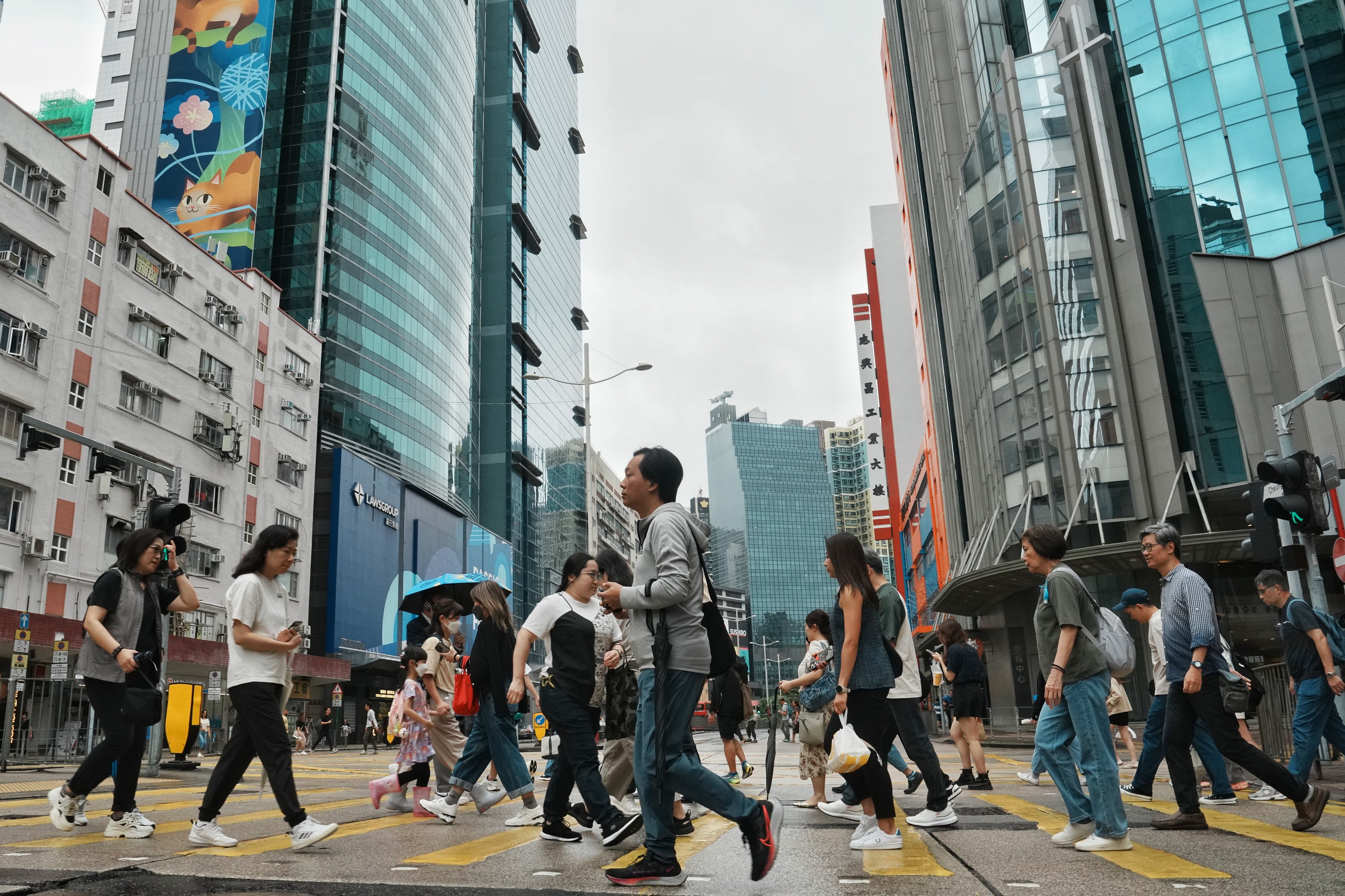 People walk across the street during lunchtime in Lai Chi Kok, on November 14, 2024. Photo: Elson Li