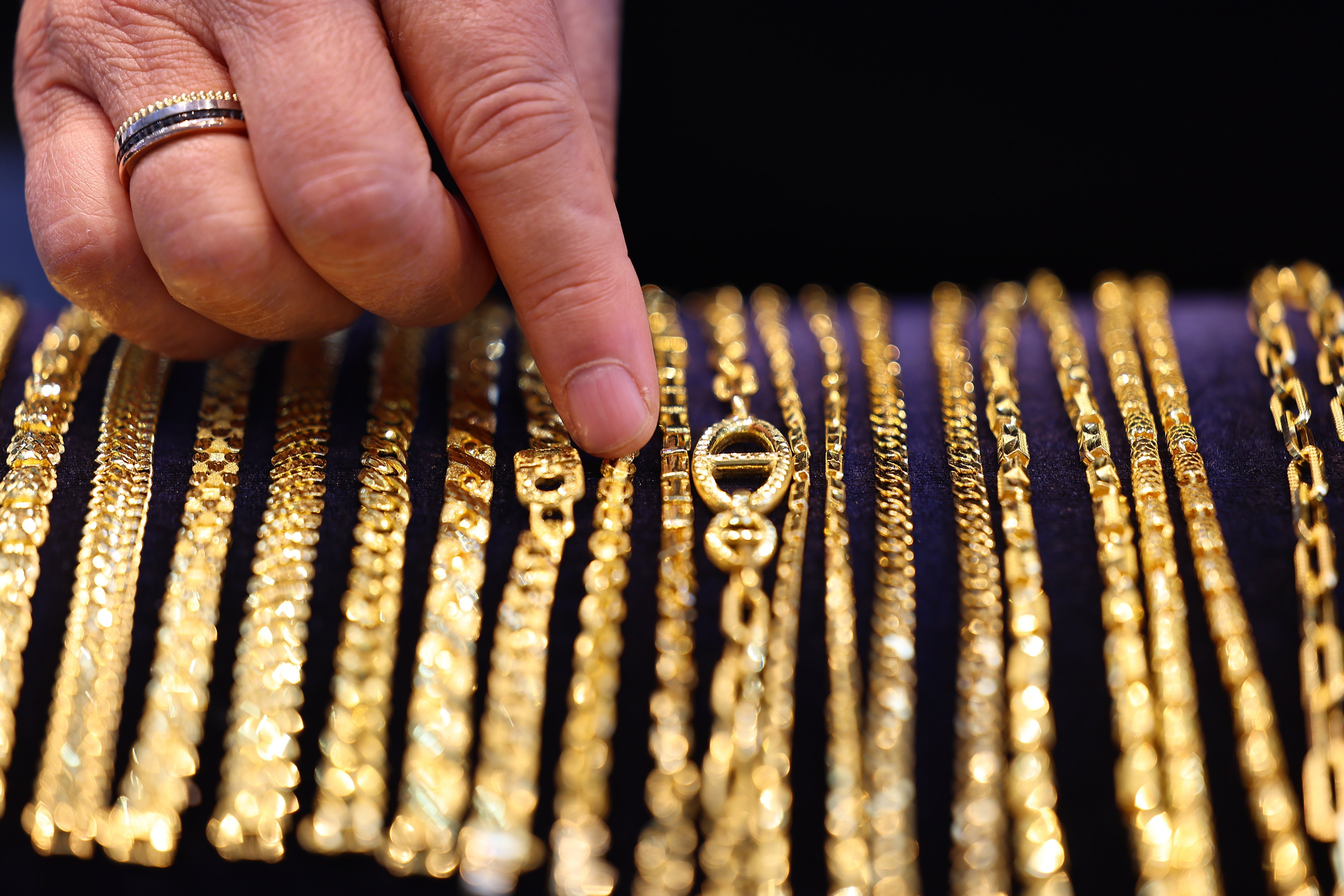 An employee displays gold bracelets at a jewellery shop in Seoul, South Korea, on February 21. Photo: EPA-EFE