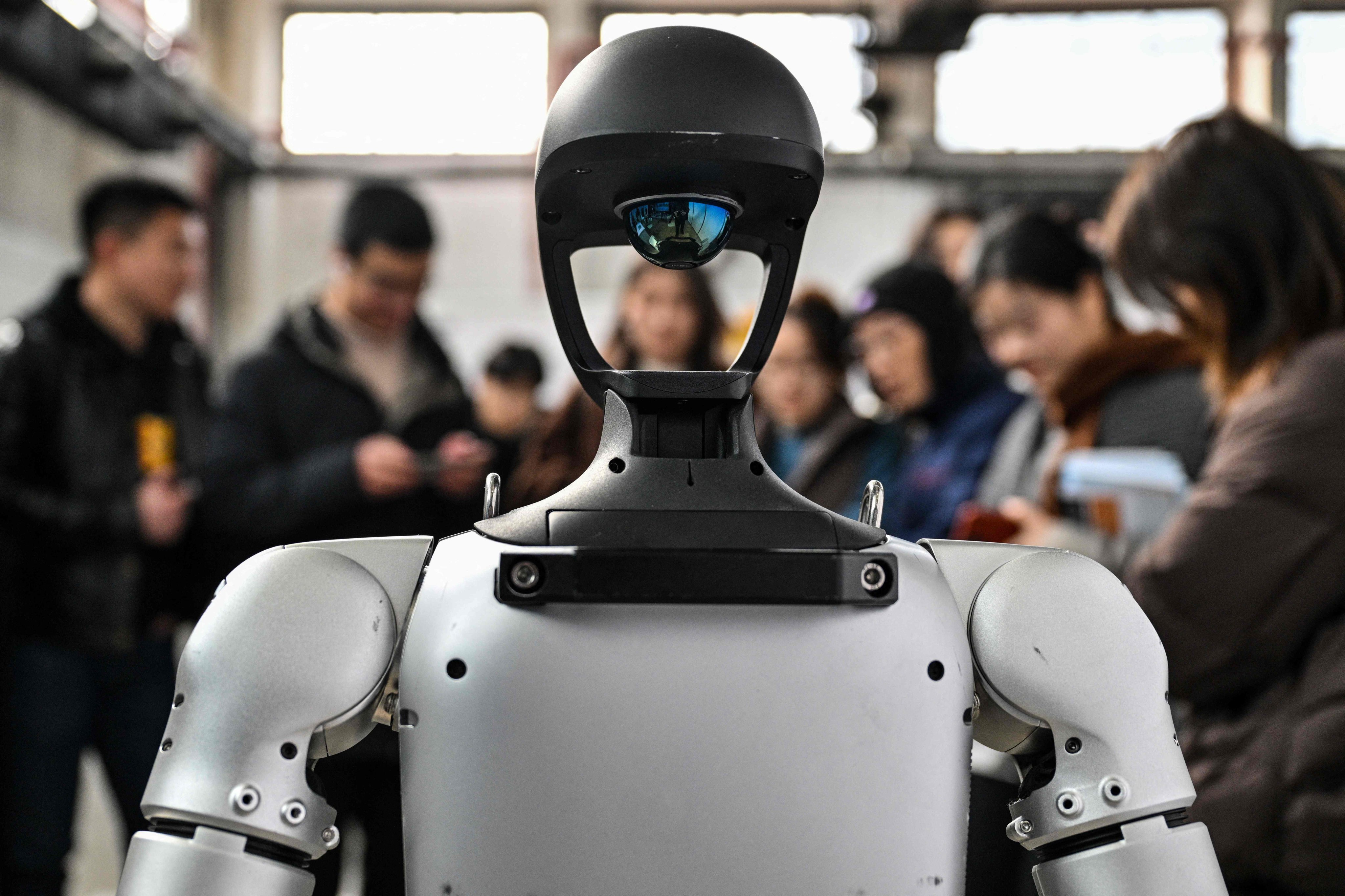 People stand next to a humanoid robot from Unitree Robotics during the Global Developer Conference, organised by the Shanghai AI Industry Association, in Shanghai on February 21. Photo: AFP