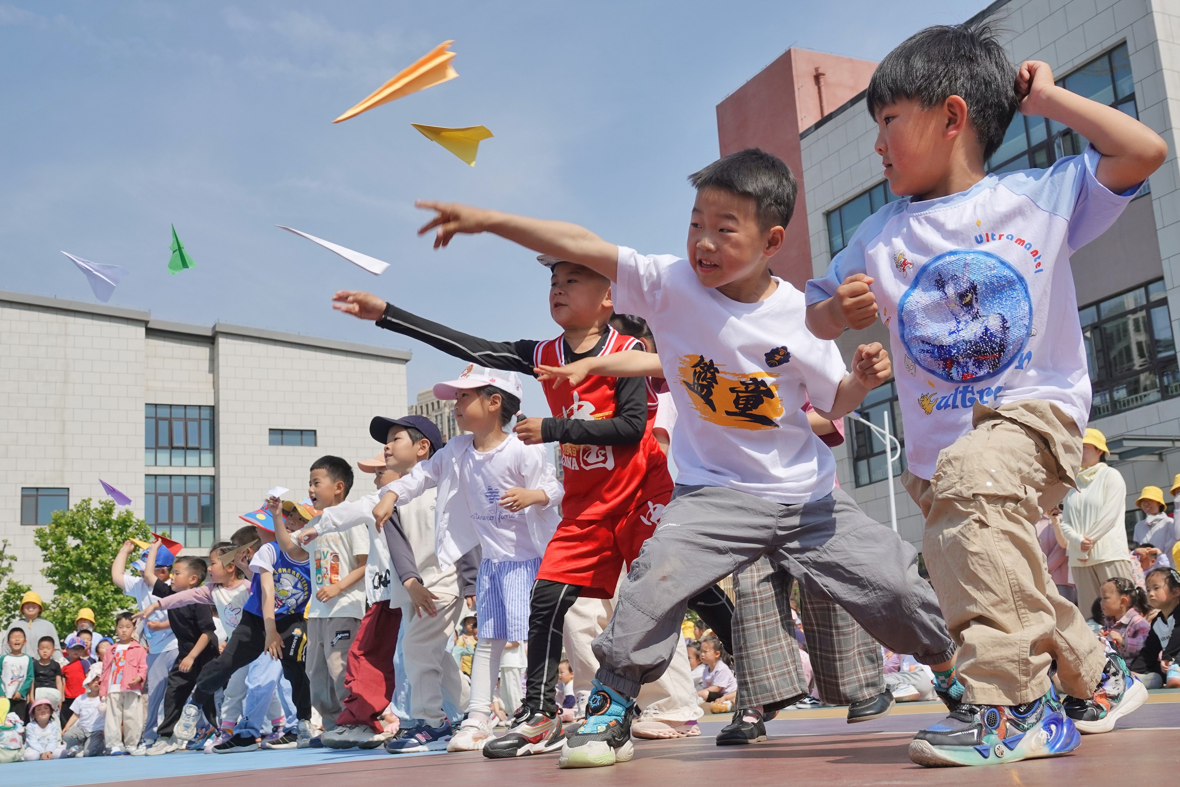 Students fly paper airplanes at a kindergarten in eastern China. Chinese lawmakers are reportedly considering proposals to provide free preschool education as part of a campaign to convince parents to have more children. Photo: Getty Images