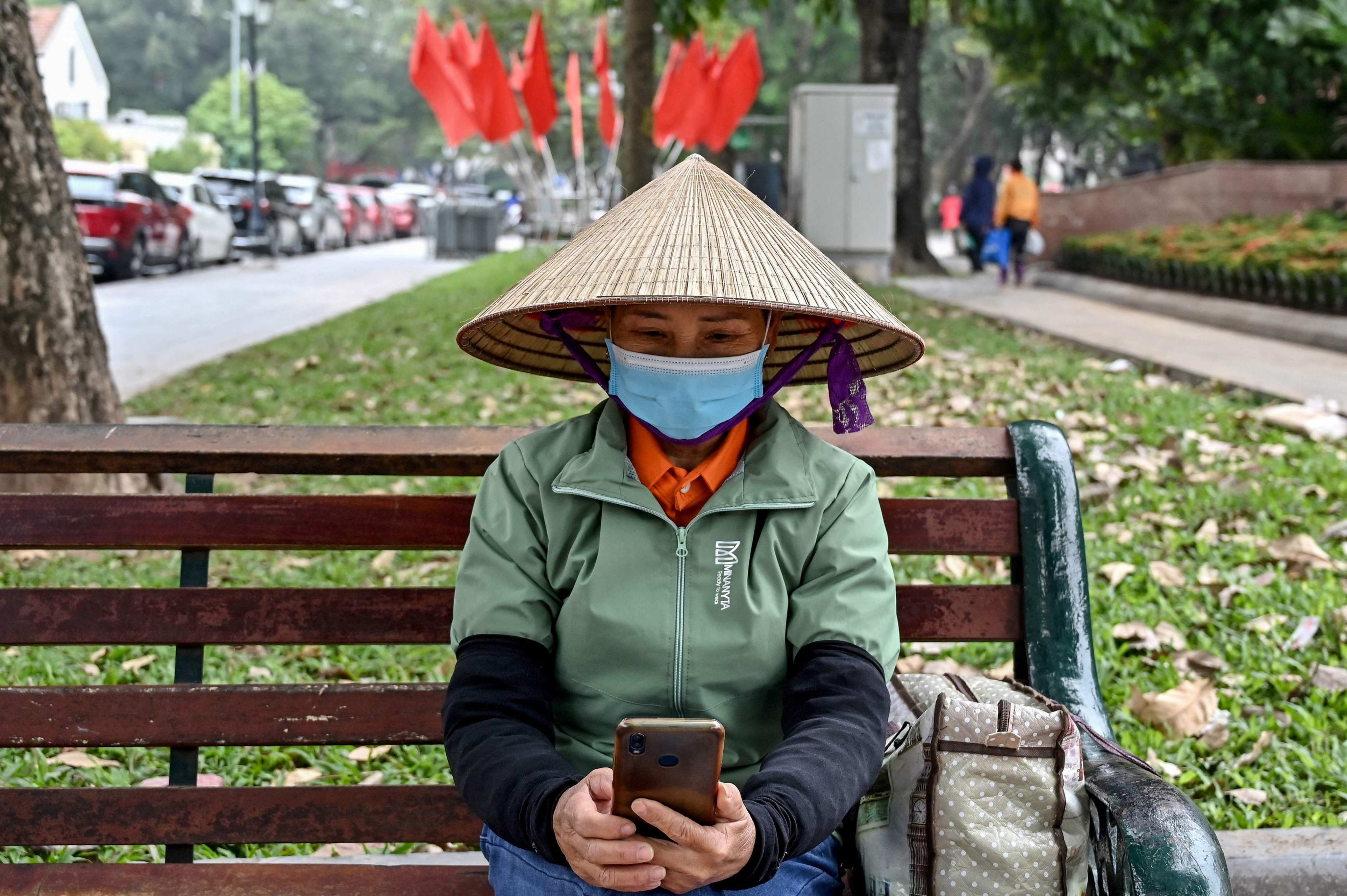 A person uses a mobile phone at a park in Hanoi, Vietnam on December 18, 2023. Photo: AFP