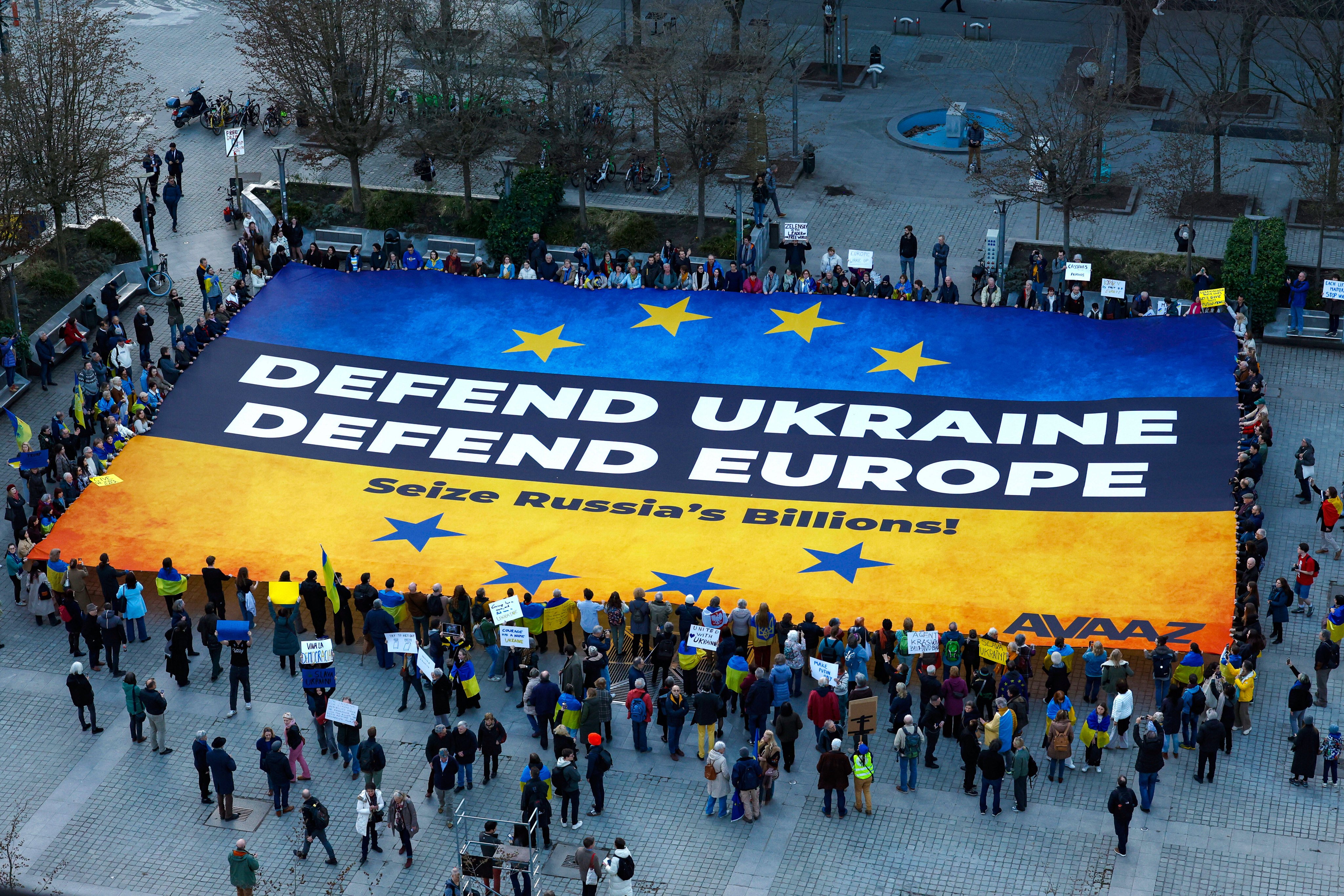 On March 5, days after the infamous Zelensky-Trump-Vance meeting in Washington, activists unfurl a large banner in support of Ukraine outside the European Council building in Brussels. Photo: AP