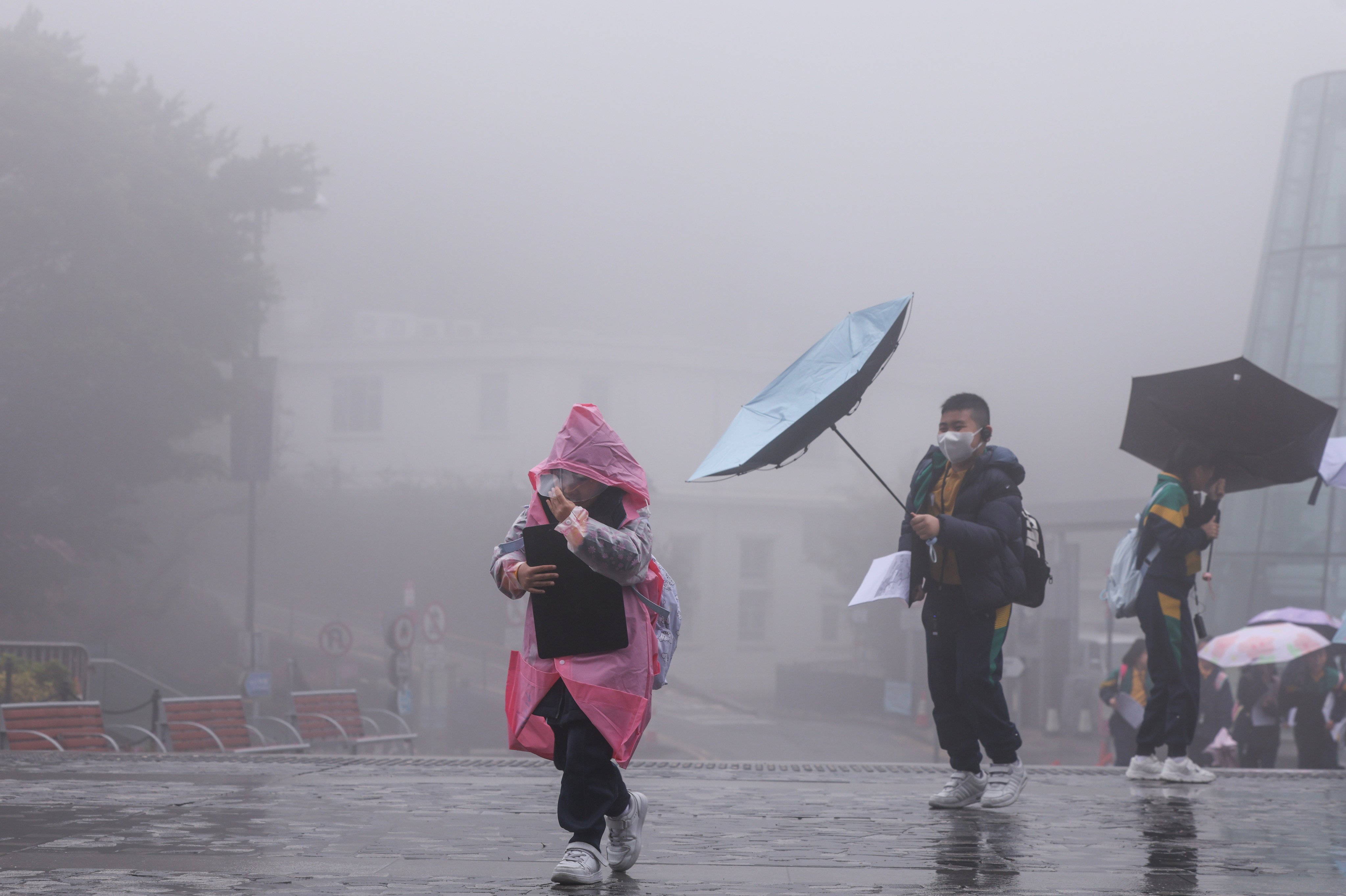 Schoolchildren brave the cold and rainy weather at The Peak. Photo: Nora Tam