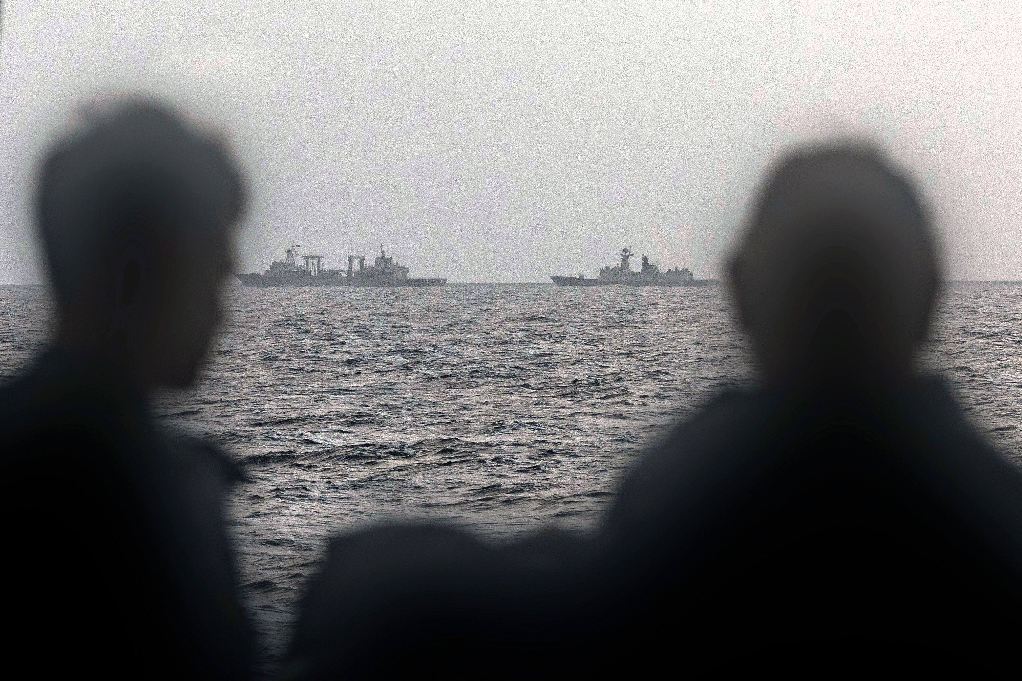 Sailors onboard the Royal Australian Navy ship HMAS Arunta look at the People’s Liberation Army-Navy Fuchi-class replenishment vessel and Weishanhu Jiangkai-class frigate Hengyang in the Tasman Sea on February 13.Photo: Australian Defence Force/AFP