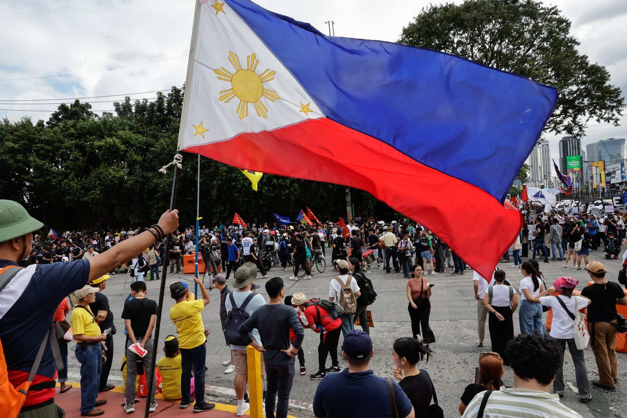 A person holds a Philippine flag at a rally marking the 39th anniversary of the EDSA People Power Revolution on February 25. Photo: EPA-EFE