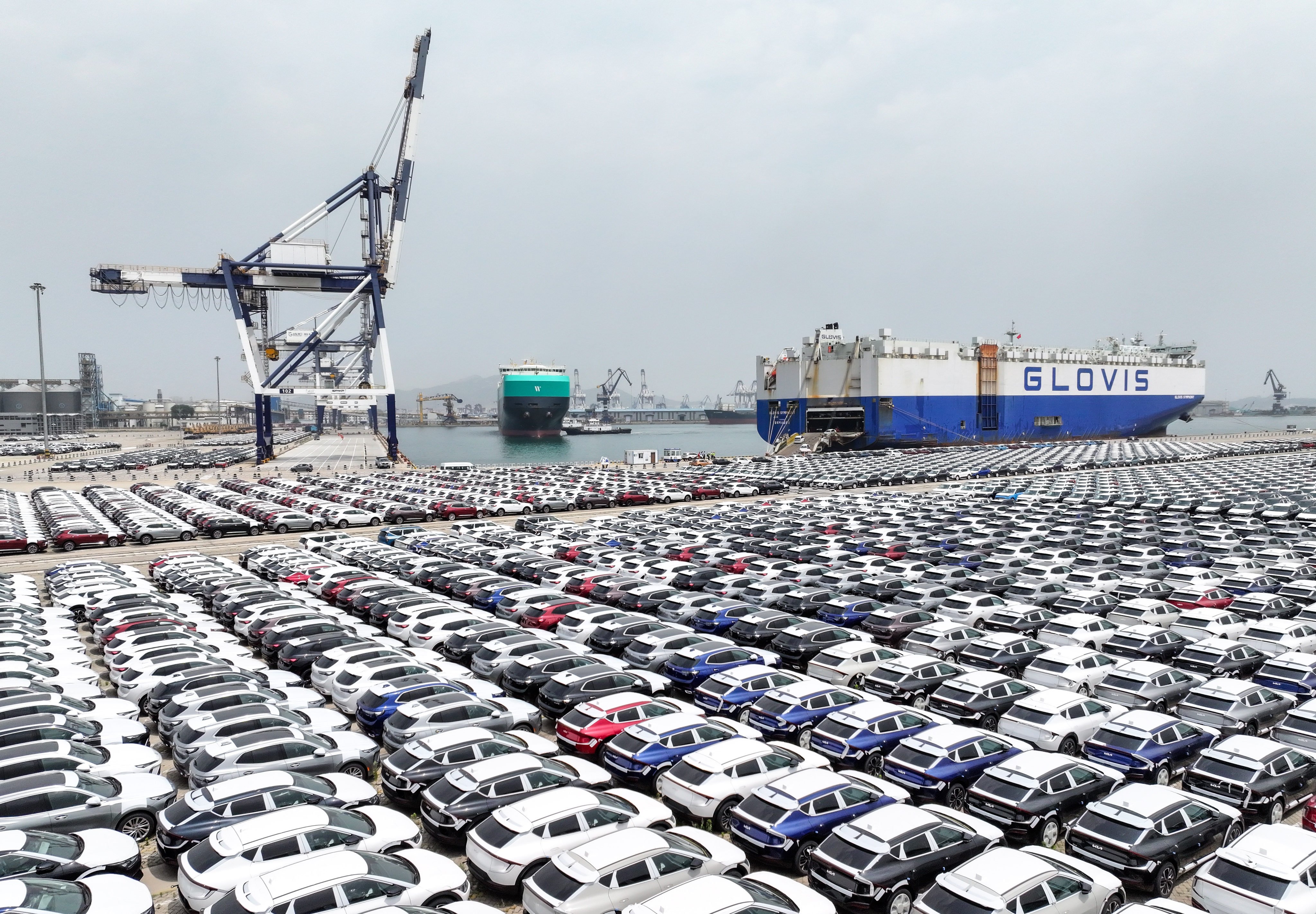 Electric cars are lined up ready to be exported at a port in eastern China. The industry is one of several in China affected by a vicious price war and excessive competition. Photo: Xinhua