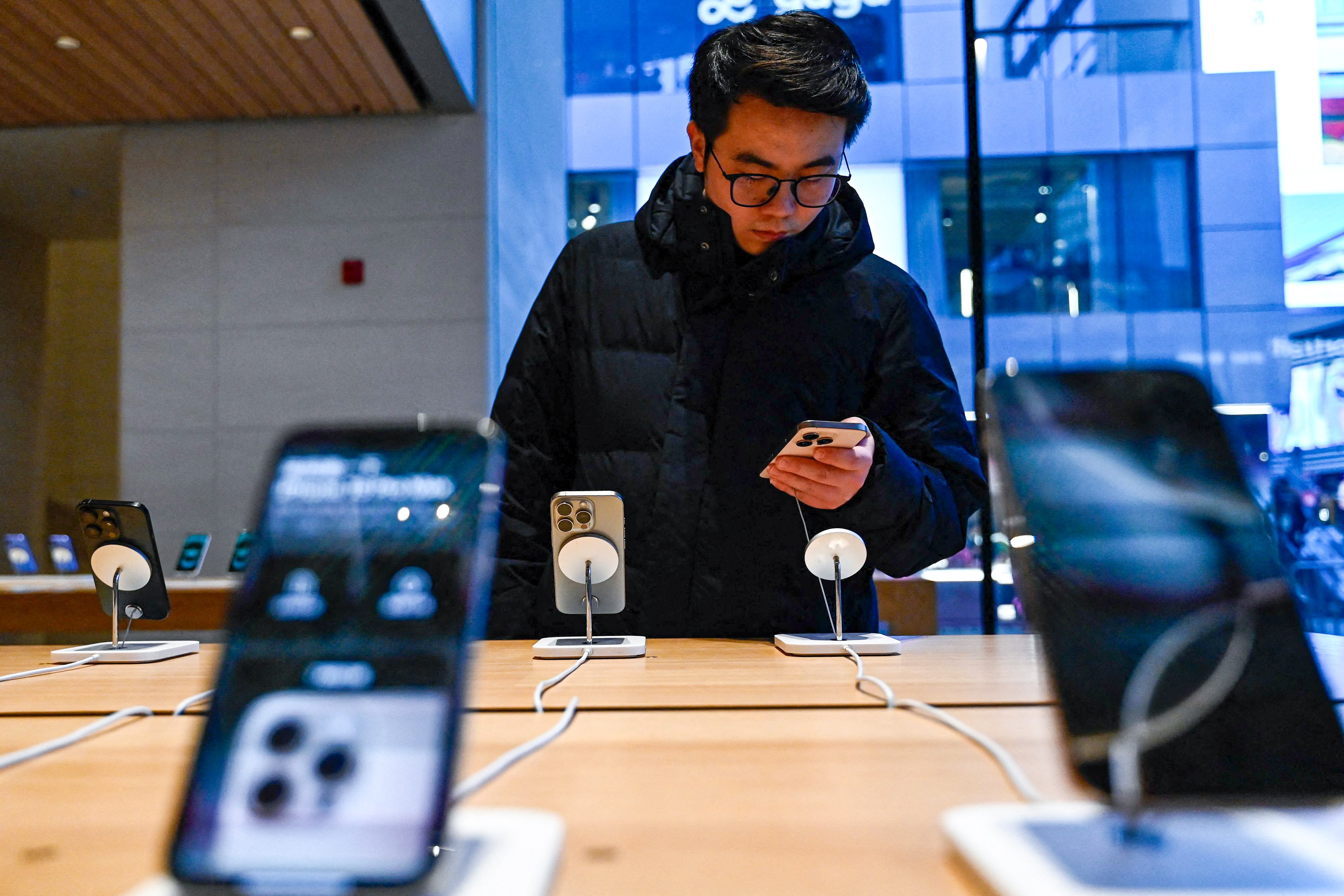 A man tests an iPhone 16 in an Apple store in Beijing on February 13, 2025. Photo: AFP