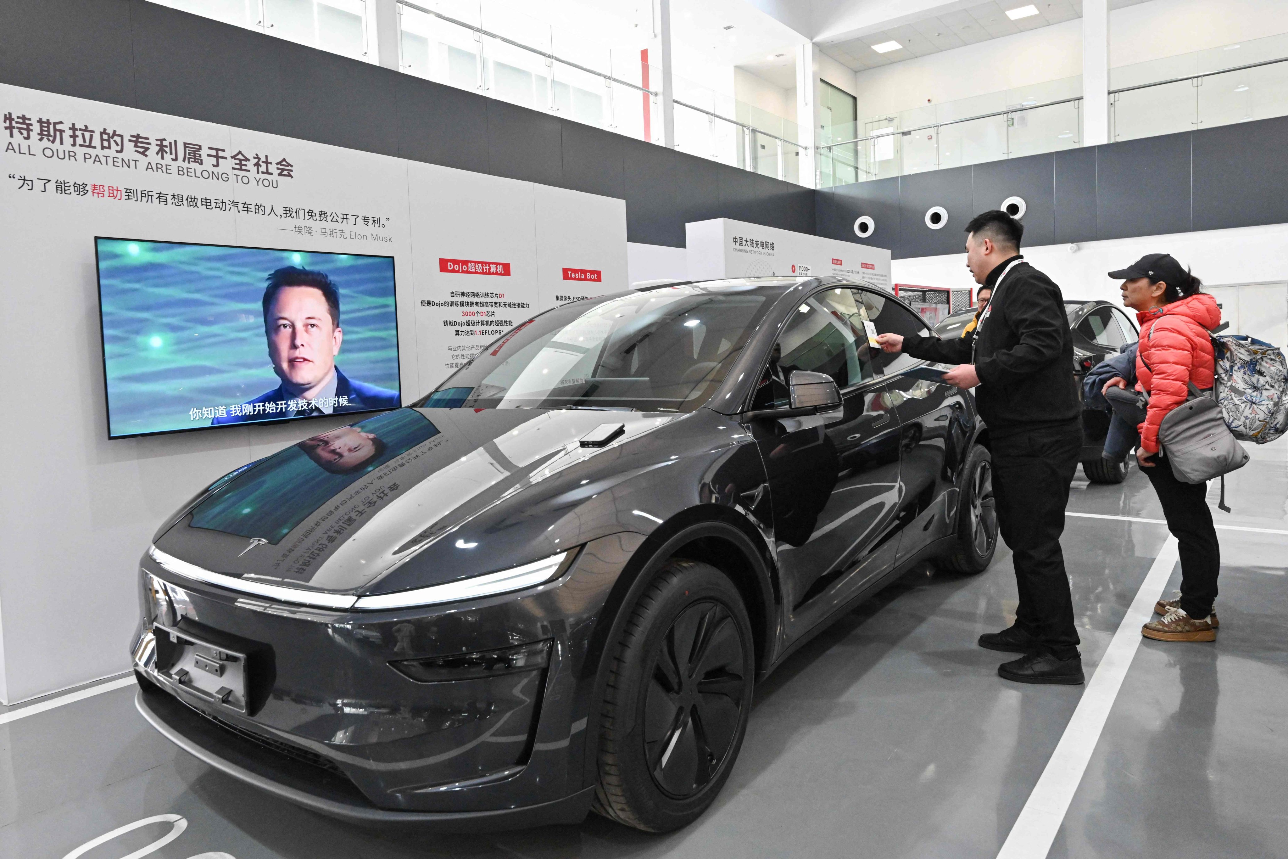 Customers check a Tesla Model Y at a delivery centre in Beijing on February 27, 2025. Photo: AFP