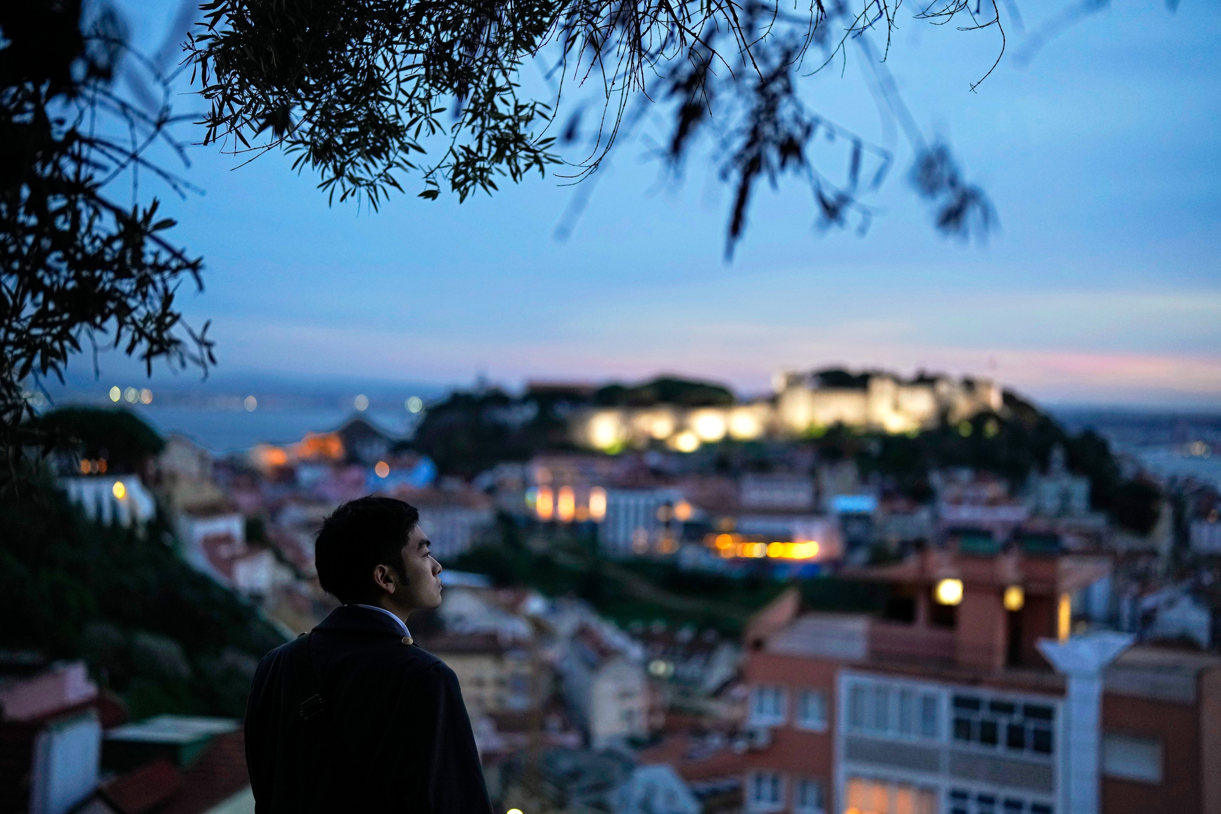 A man looks at the view from the Our Lady of the Hill viewpoint overlooking downtown Lisbon and the Saint George’s castle, on February 26, 2025. Photo: AP