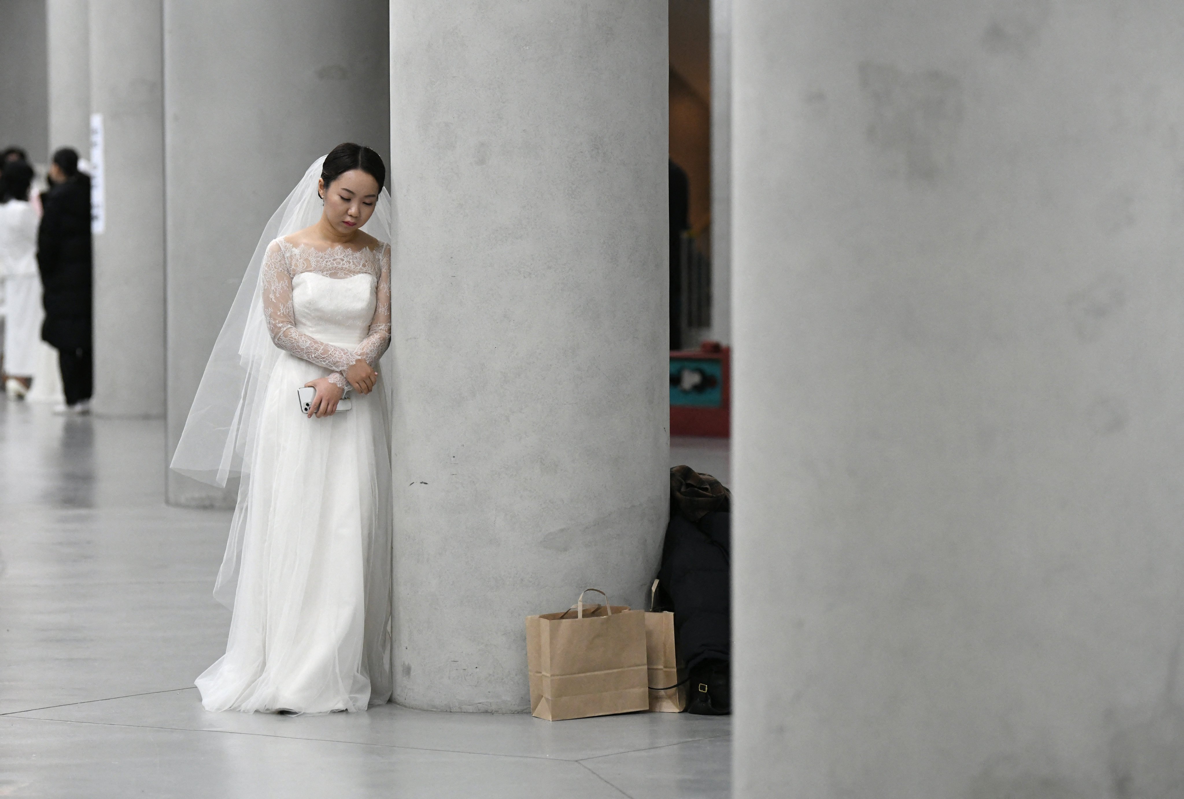 A bride leans on a pillar before a mass wedding ceremony organised by the Unification Church at Cheongshim Peace World Center in Gapyeong, South Korea, on February 7, 2020. A new study of young Koreans’ internet posts found that 67.1 percent of marriage-related posts reflected negative sentiment. Photo: AFP