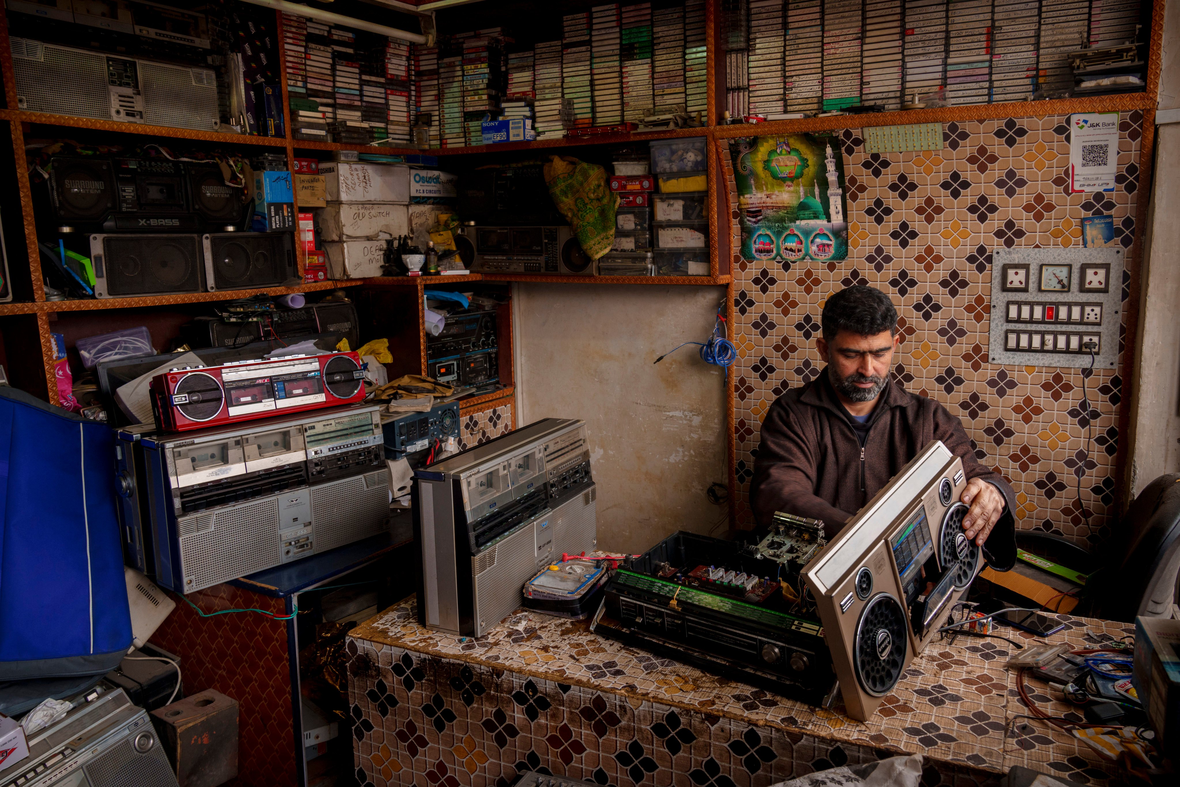 Self-taught tape recorder mechanic Mohammad Ashraf Matoo repairs a tape recorder at his shop in Srinagar, Indian-administered Kashmir. Cassette tapes remain popular in the region among lovers of its Sufi music. Photo: AP