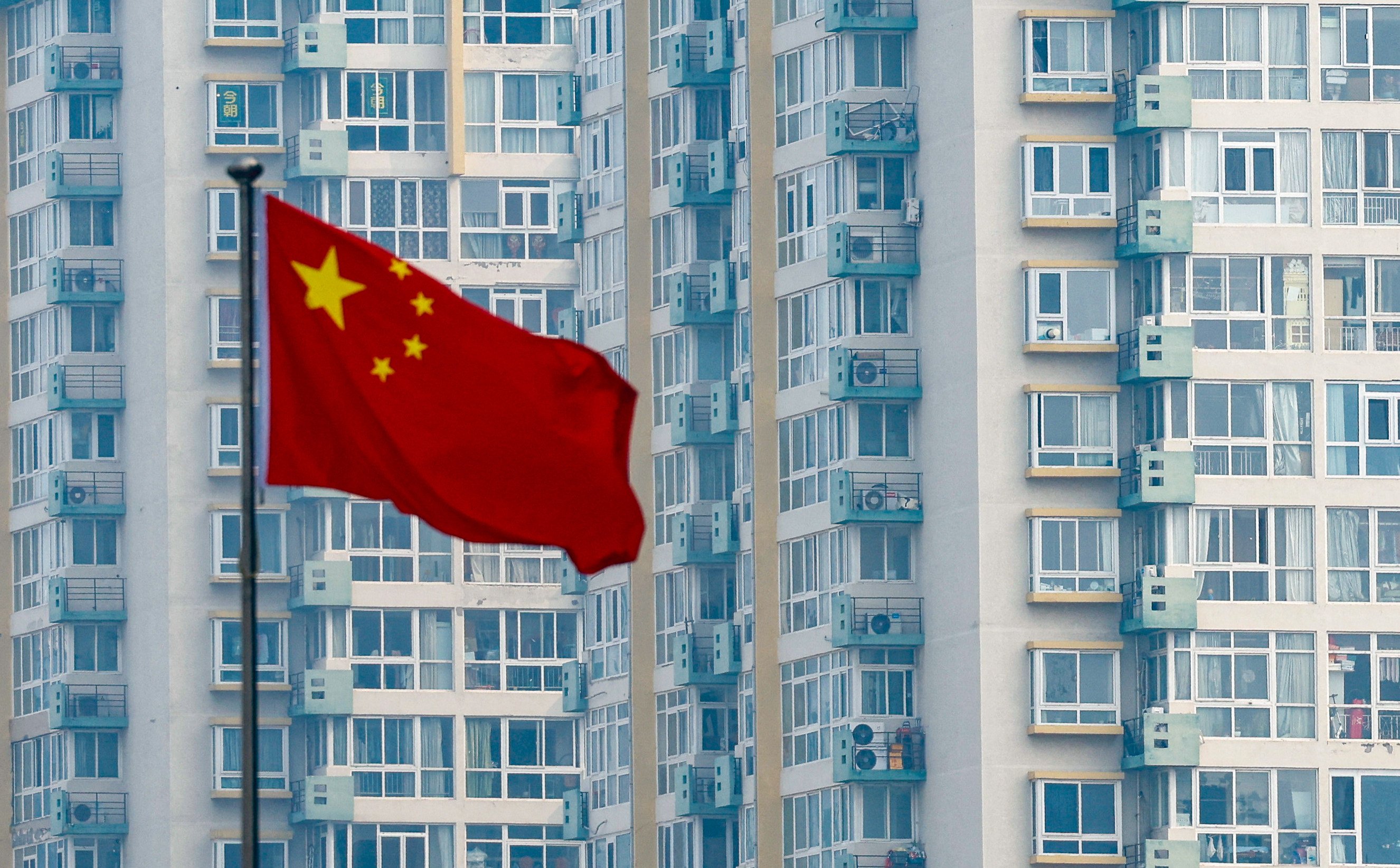 A Chinese national flag flutters near residential buildings in Beijing on March 9, 2025. Photo: Reuters